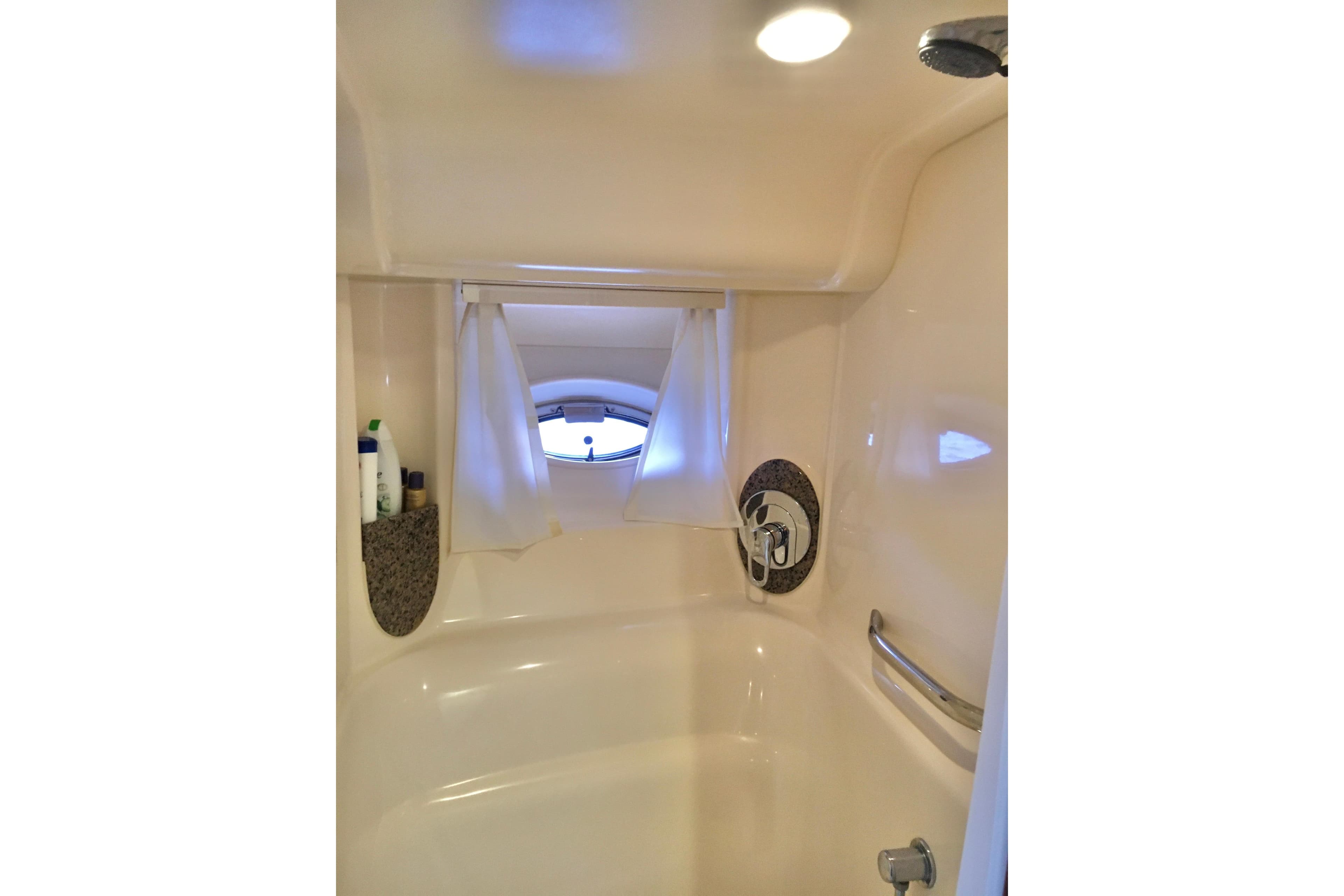 Bathroom interior of 2005 Sea Ray 420 Sundancer yacht with shower and porthole window.