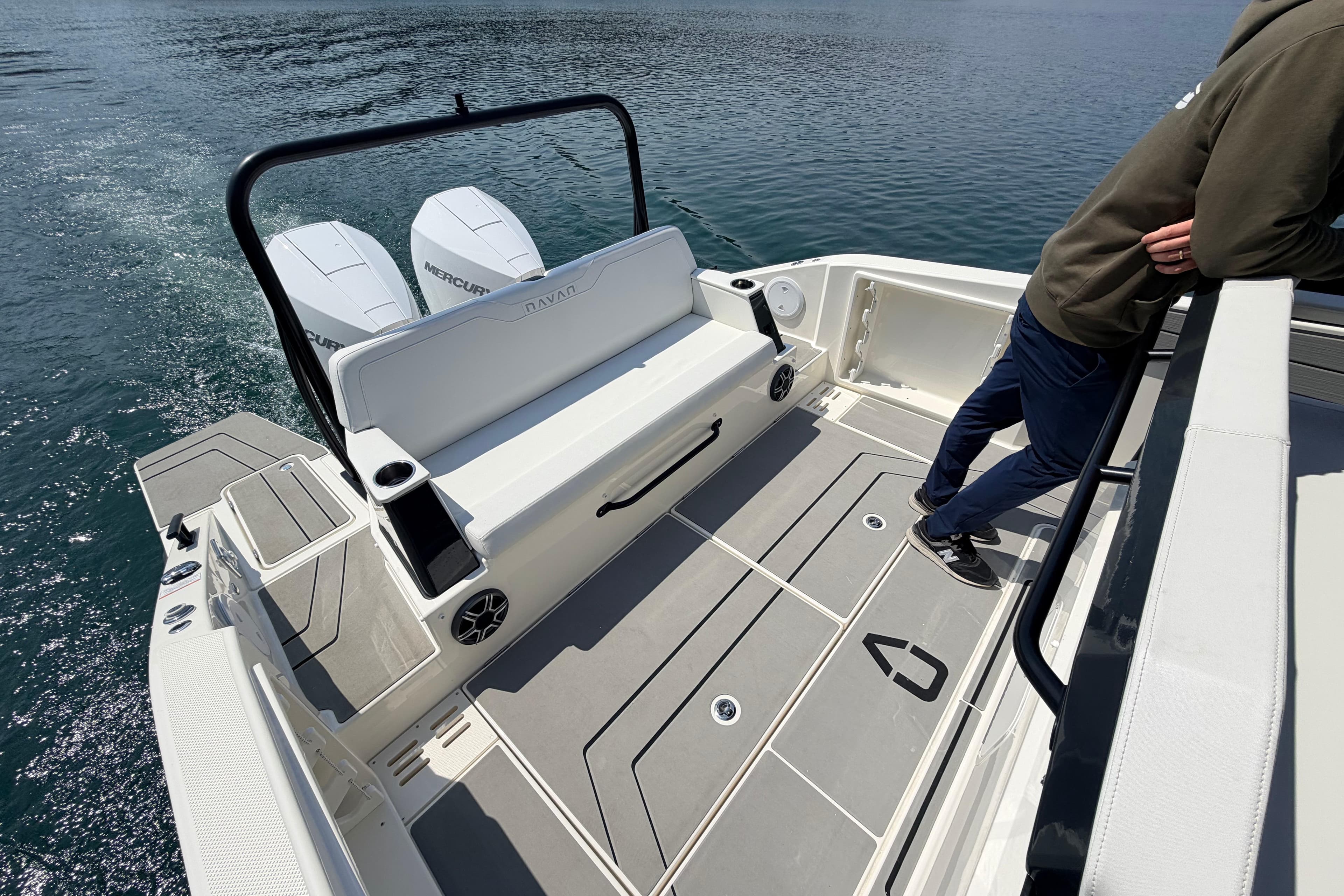 Navan T30 boat deck with dual Mercury engines, 2027 model, person leaning on railing.