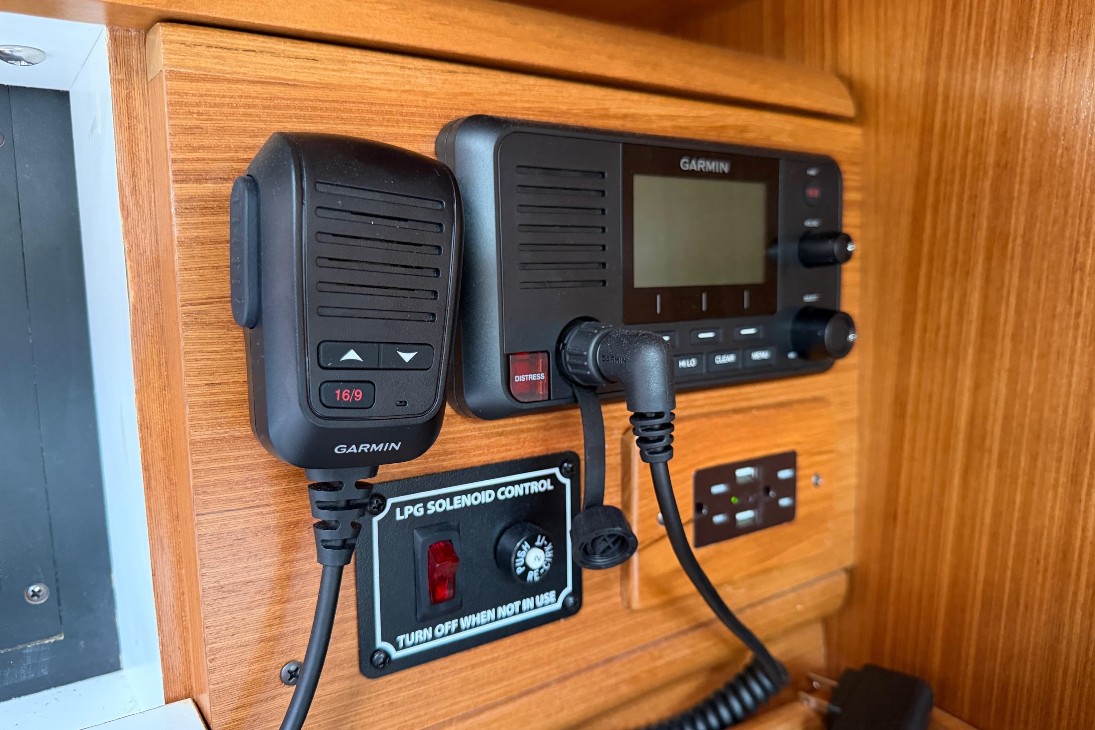 Garmin marine radio and controls on 2023 Catalina 425 yacht's wooden panel.