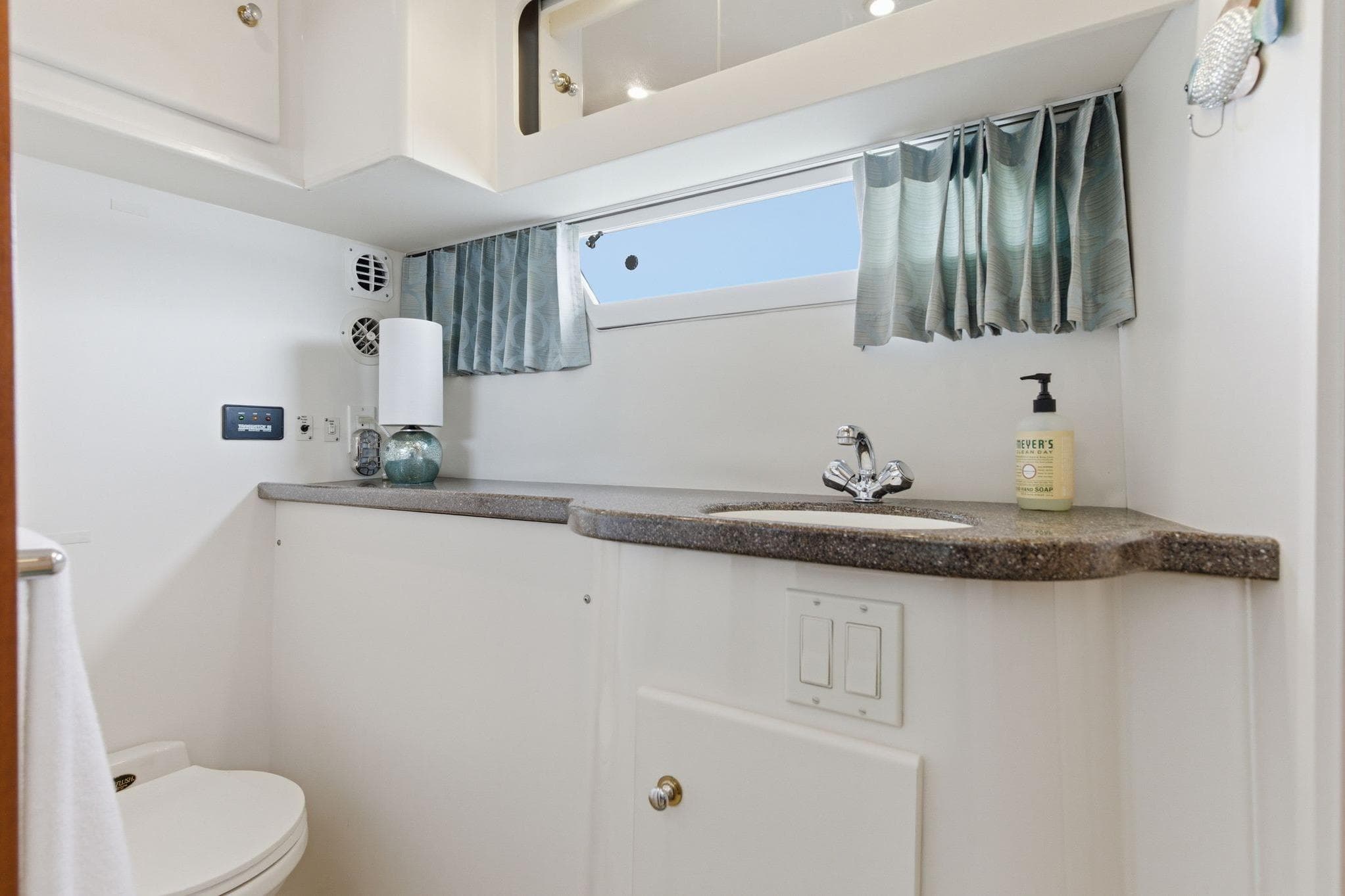 1998 Carver 445 Aft Cabin Motor Yacht bathroom with sink, toilet, and window.