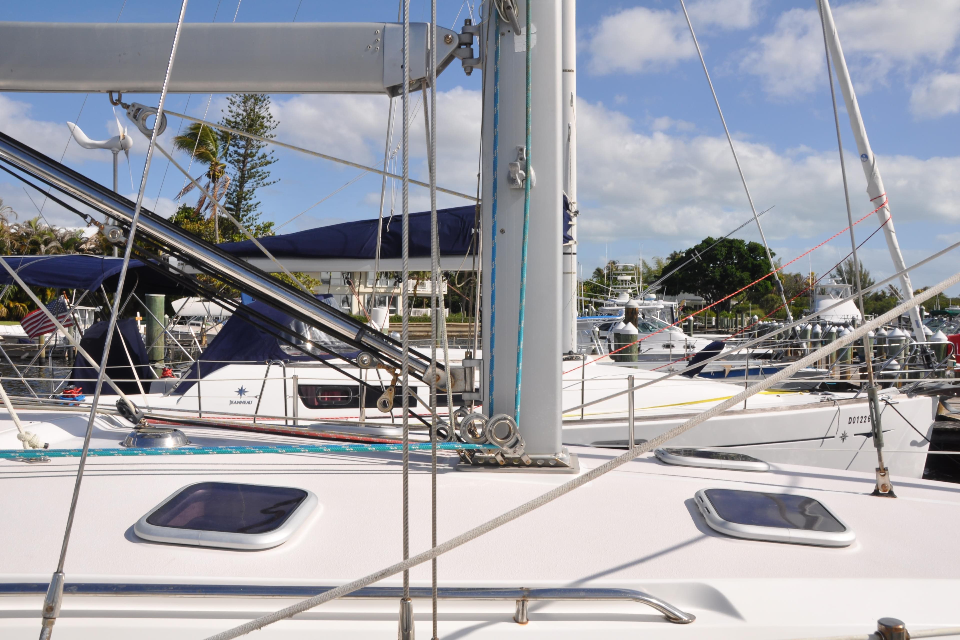 Sailboats docked at marina, featuring a 2003 Catalina 387 under clear skies.