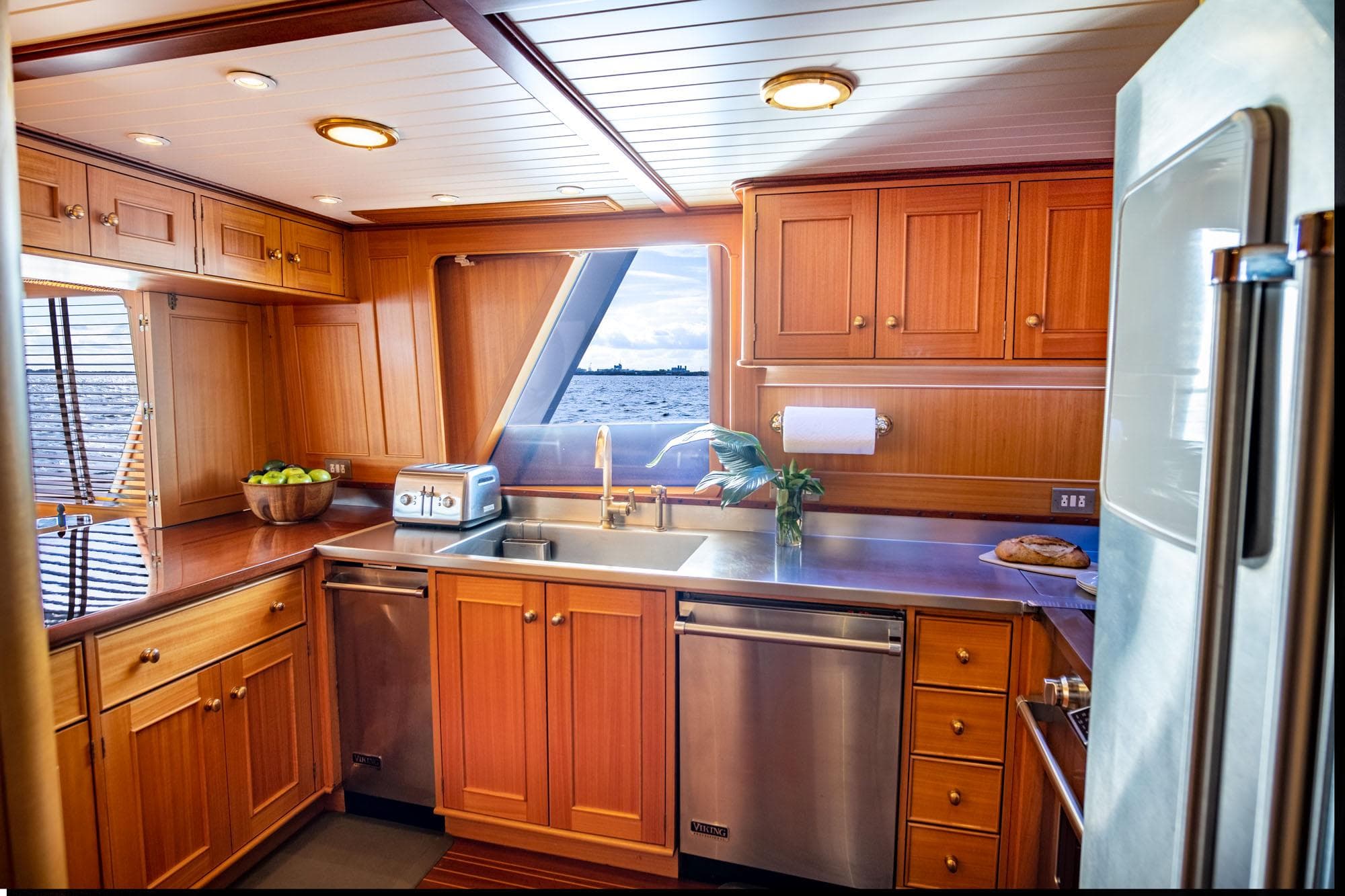 Luxurious 1999 Palmer Johnson motor yacht kitchen with wooden cabinetry and modern appliances.