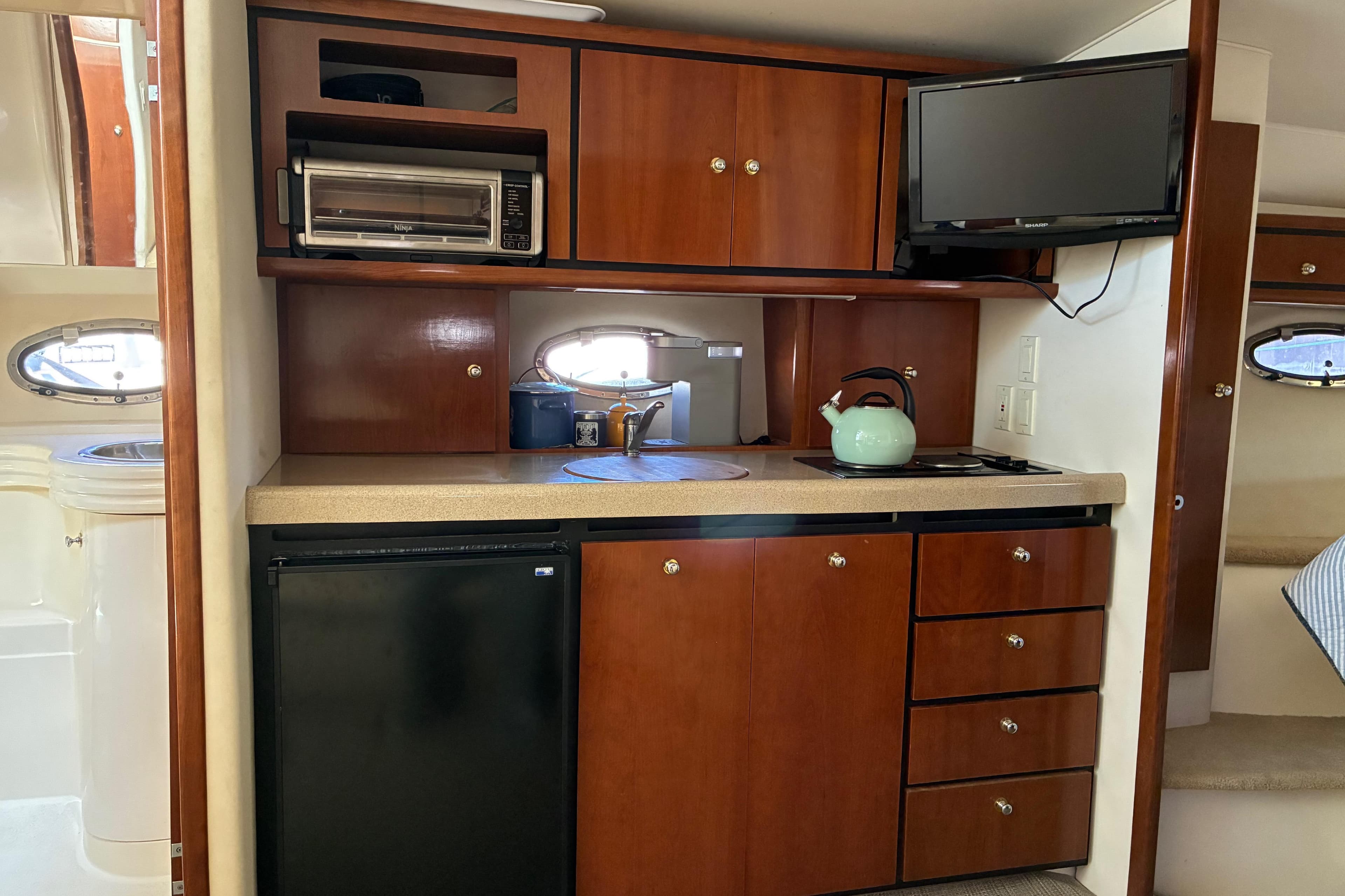 1999 Trojan 360 Express yacht kitchen with wooden cabinets, appliances, and a compact design.