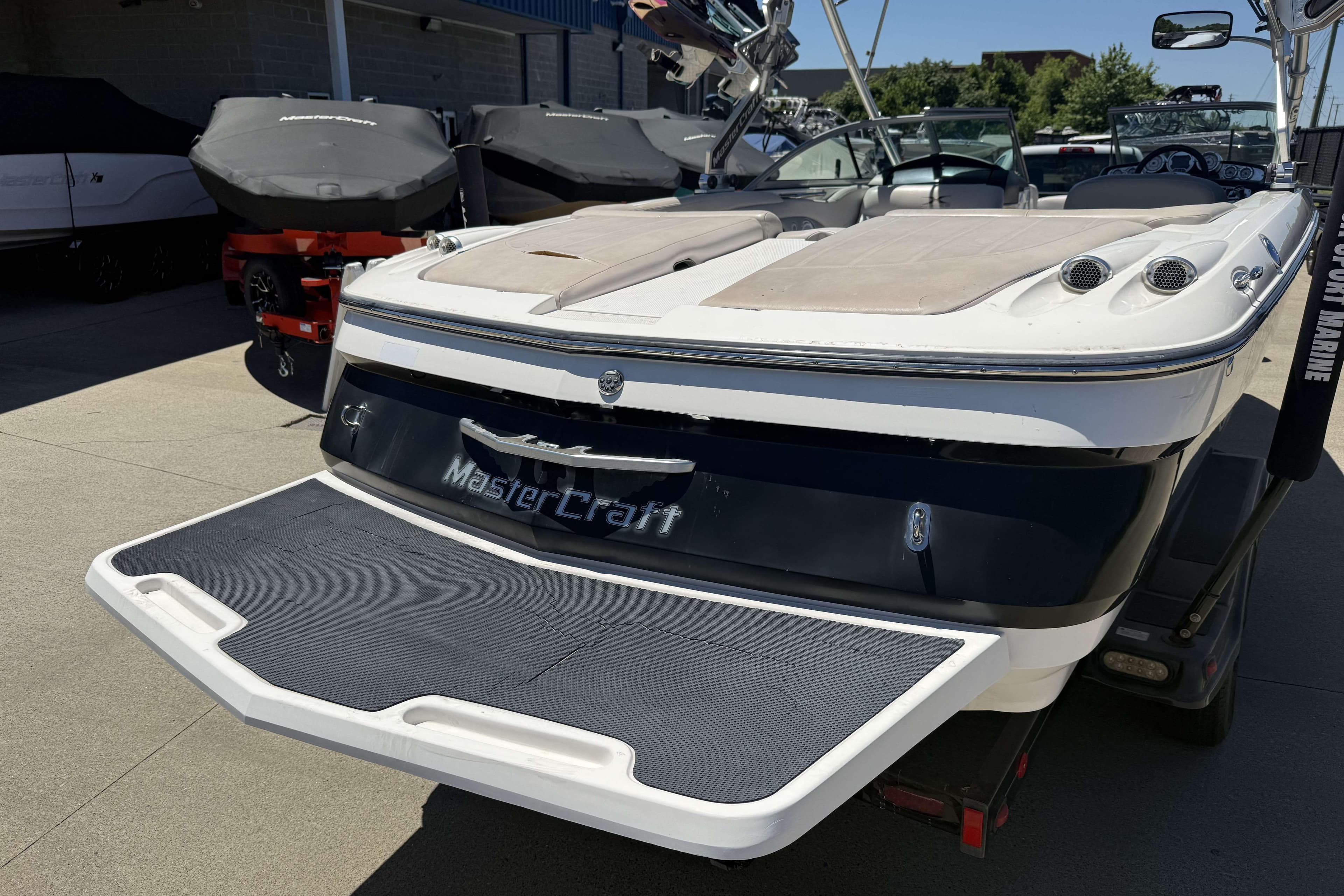 2008 MasterCraft X-45 boat with swim platform, parked outdoors.