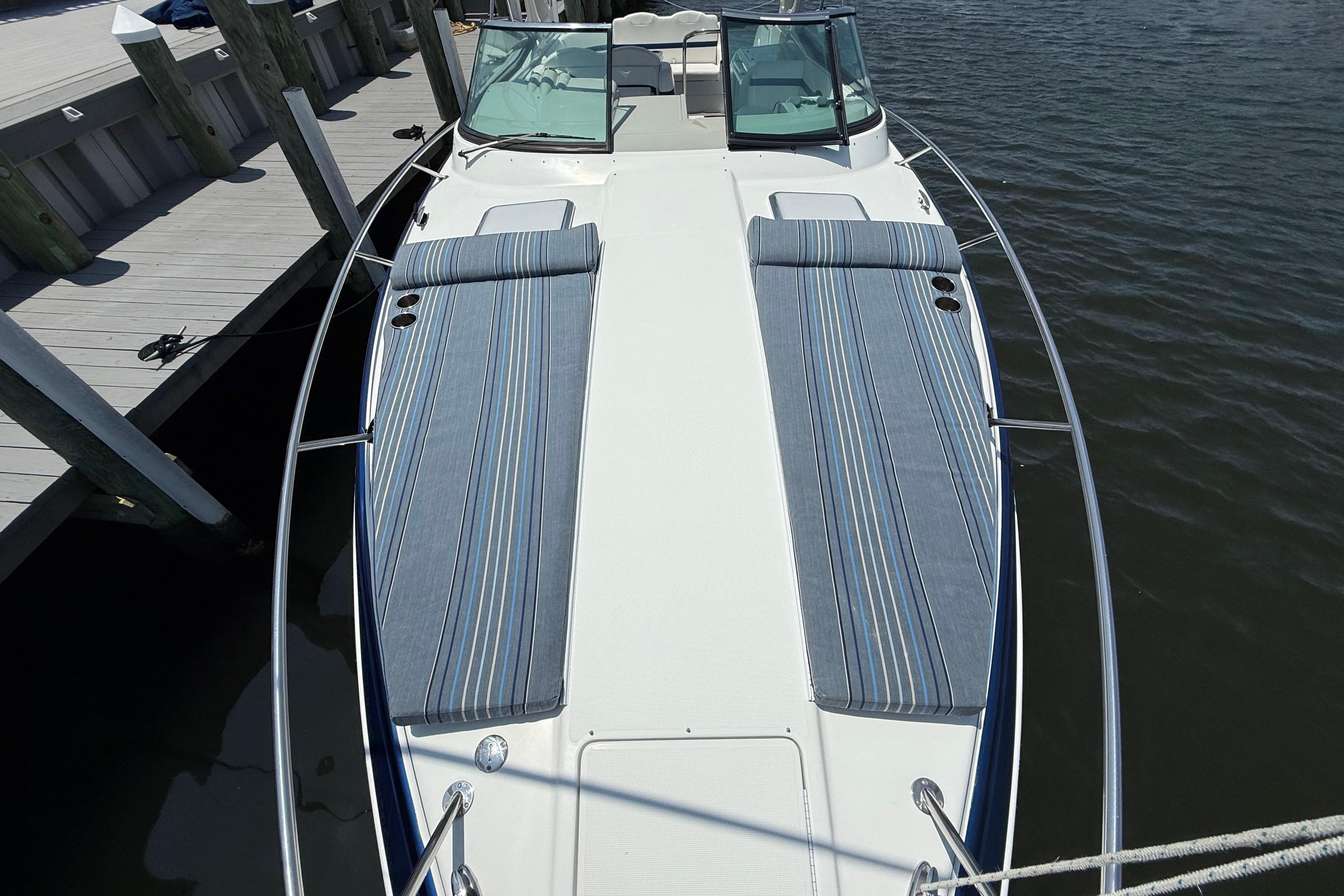2012 Formula 350 Sun Sport boat docked, featuring striped sunbathing cushions on deck.