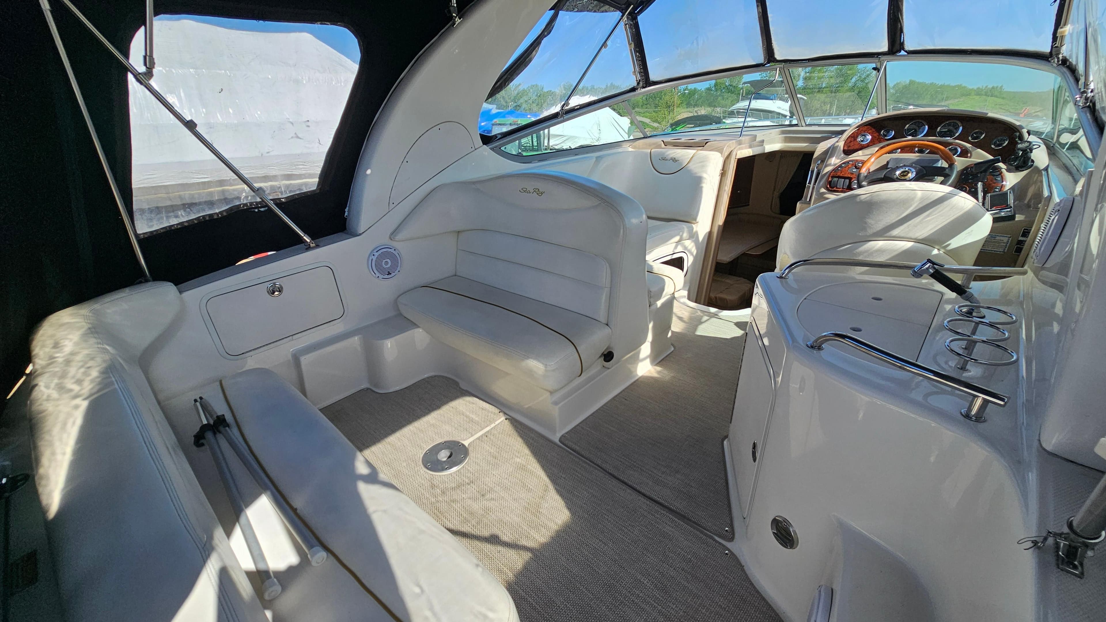 Interior of 2003 Sea Ray 280 Sundancer boat with seating and helm station.