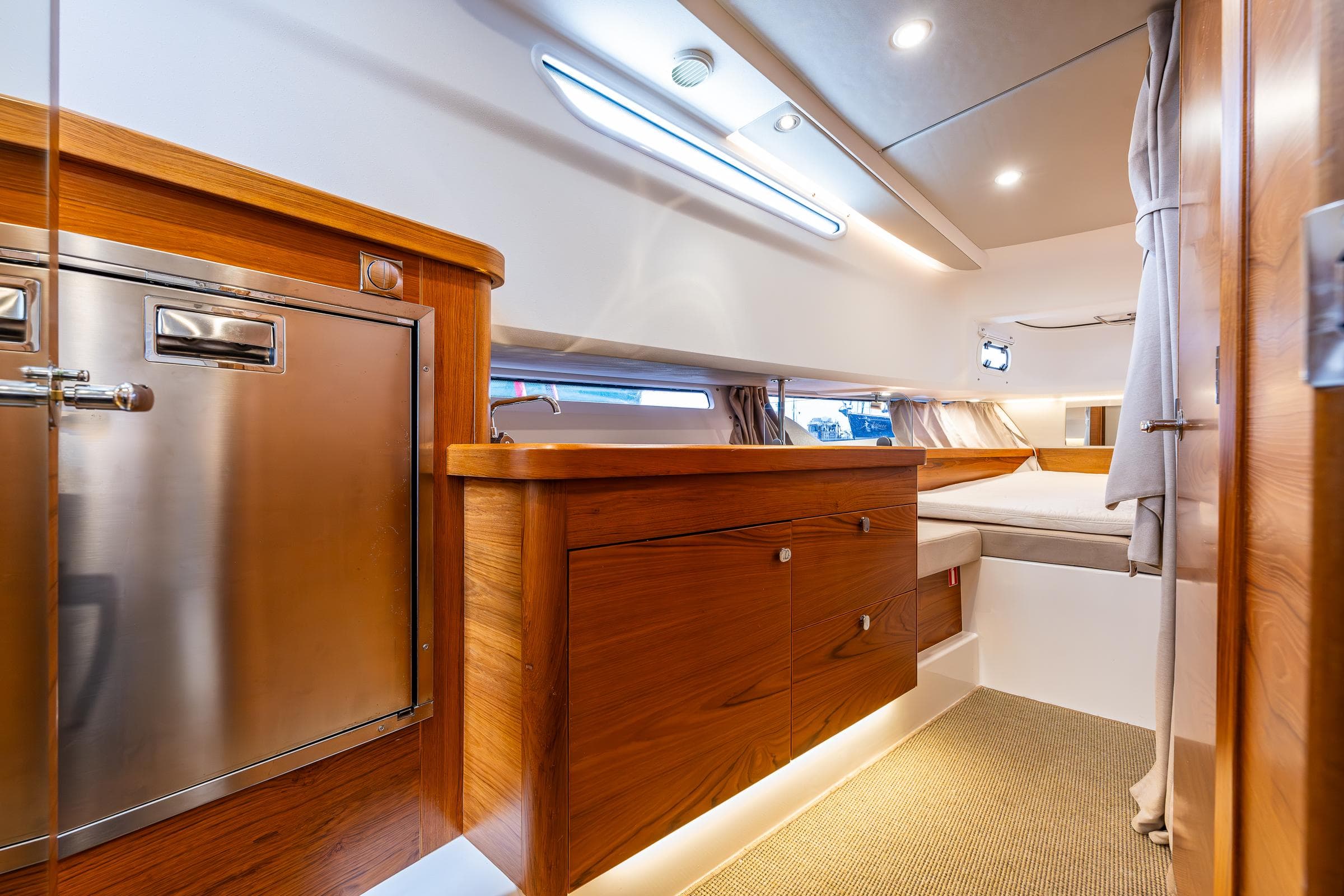 Luxurious interior of 2021 Nimbus C11 yacht with wooden cabinetry and modern lighting.