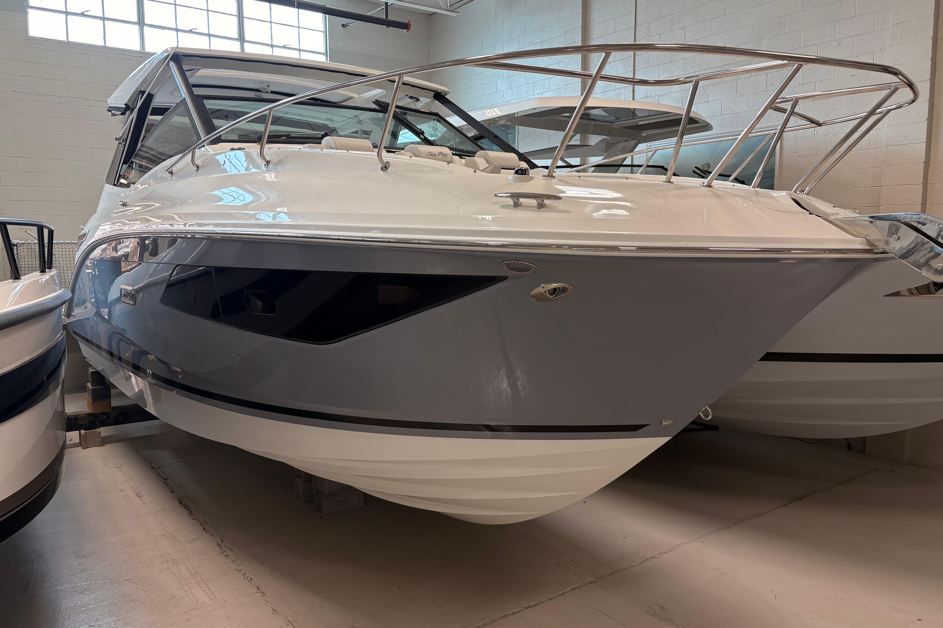 2026 Sea Ray Sundancer 320 boat in showroom, showcasing sleek design and modern features.