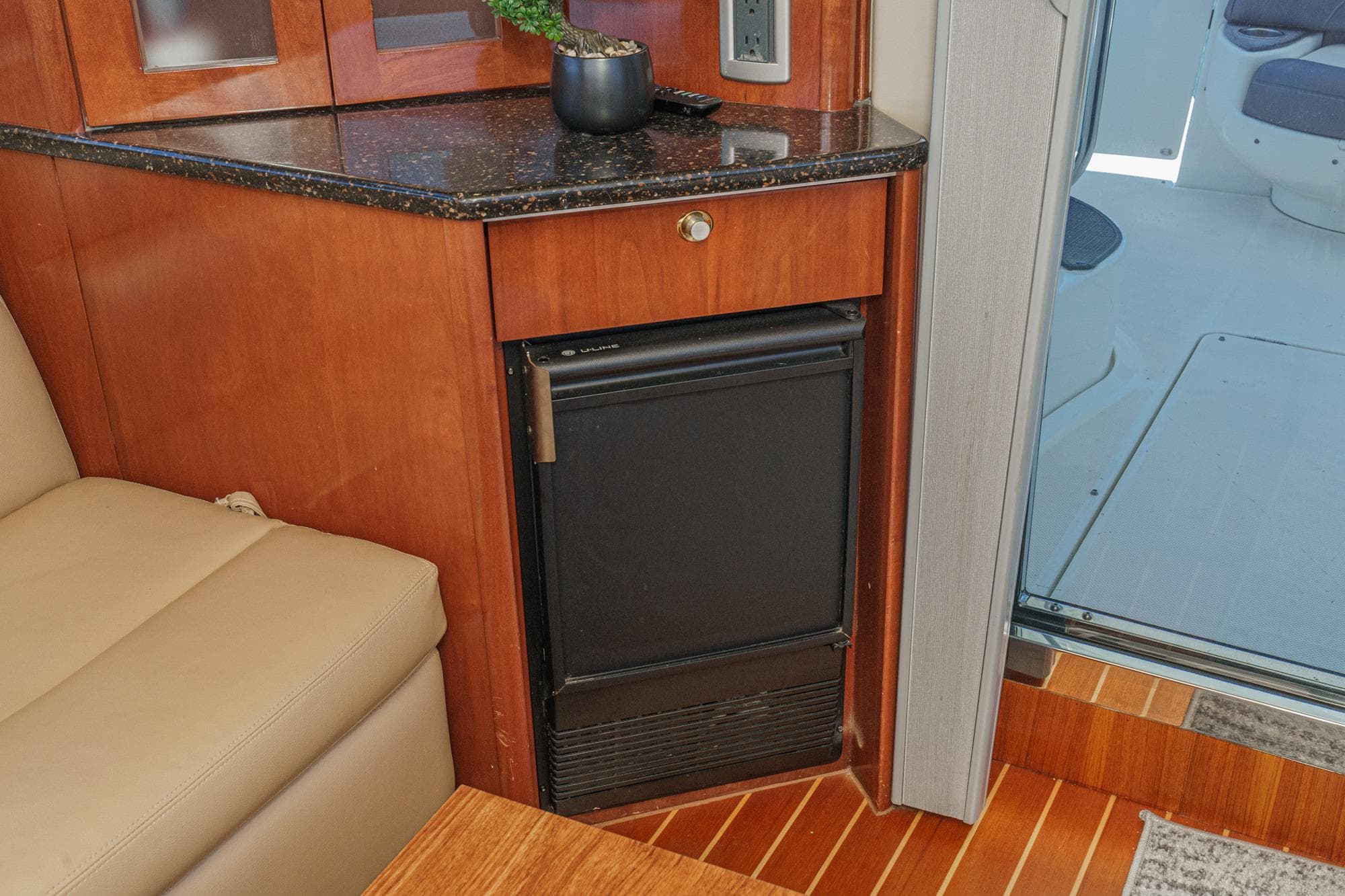 Luxury interior of 2009 Meridian 441 Sedan yacht with compact fridge and wooden cabinetry.