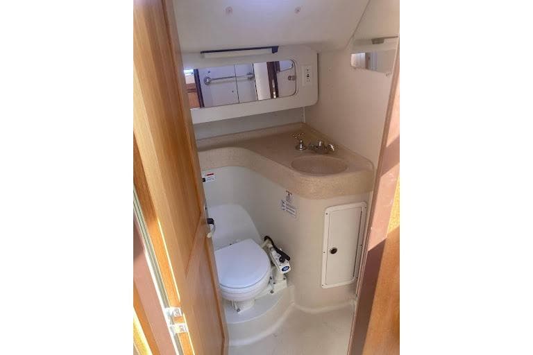 Bathroom interior of a 2001 Catalina 380 yacht, featuring a compact toilet and sink.