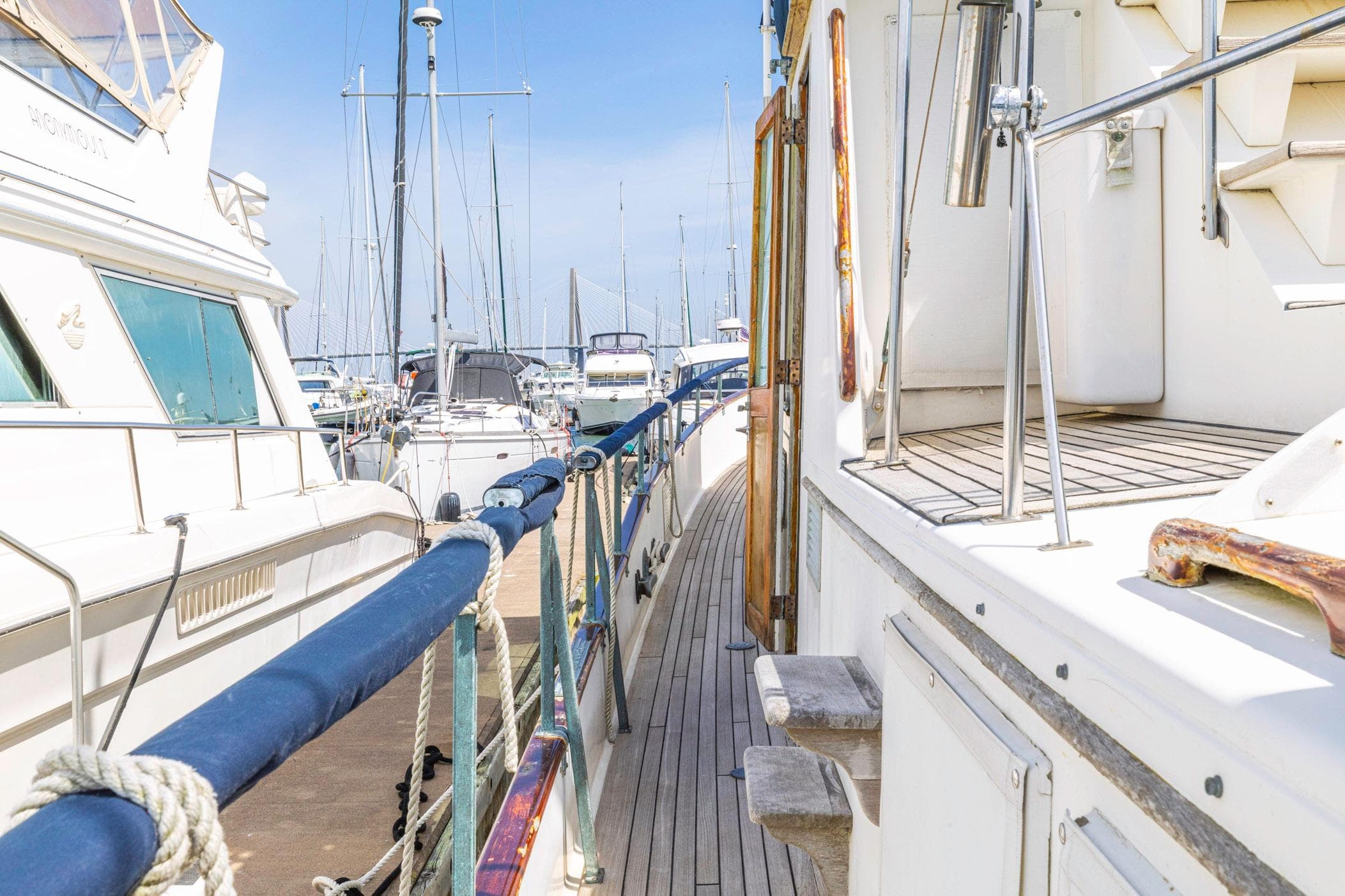 1983 Grand Banks 49 Classic yacht docked in a marina, showcasing its elegant wooden deck.