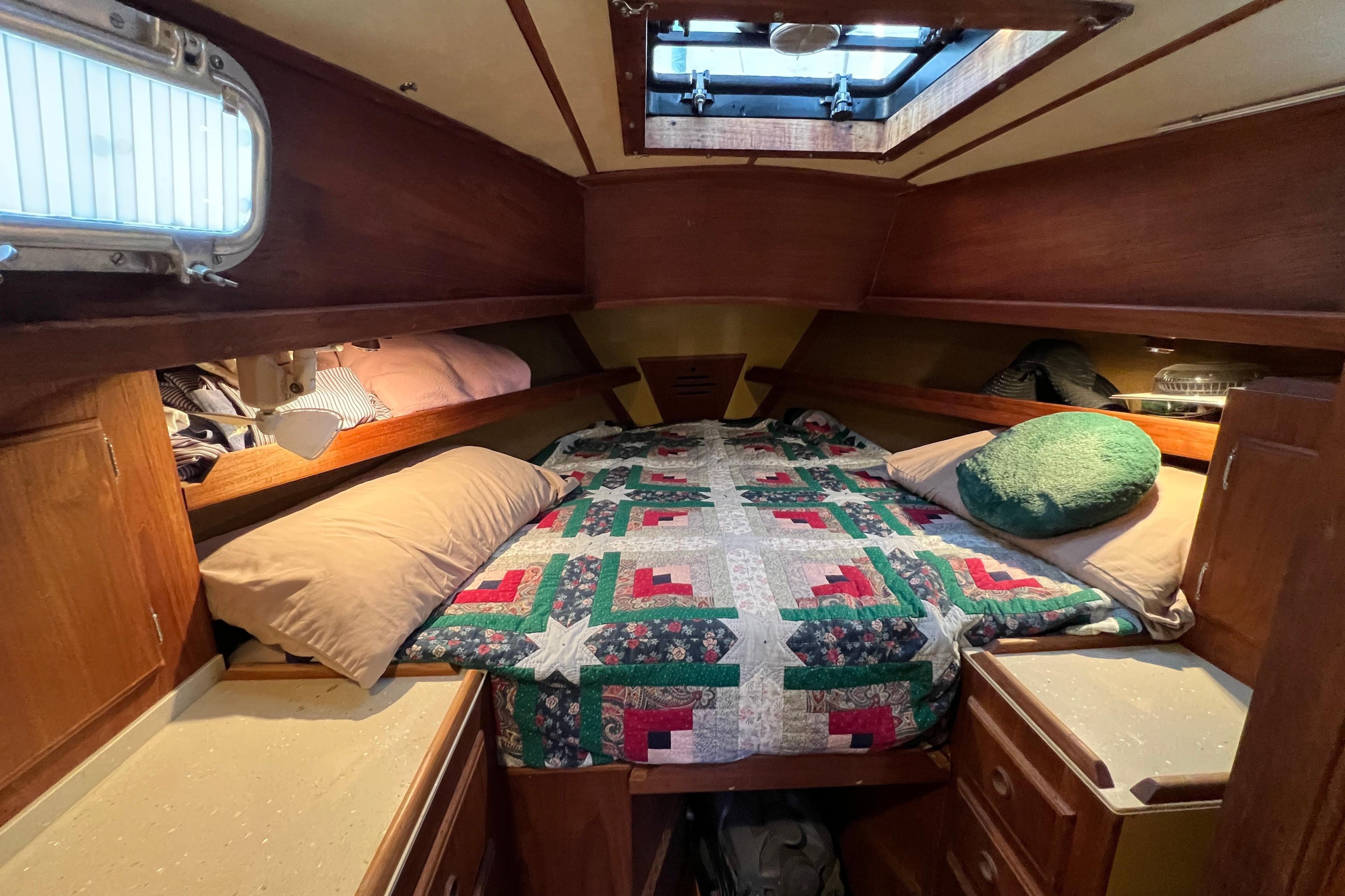 Cozy cabin interior of 1979 Pearson 424 sailboat with colorful quilted bedding.