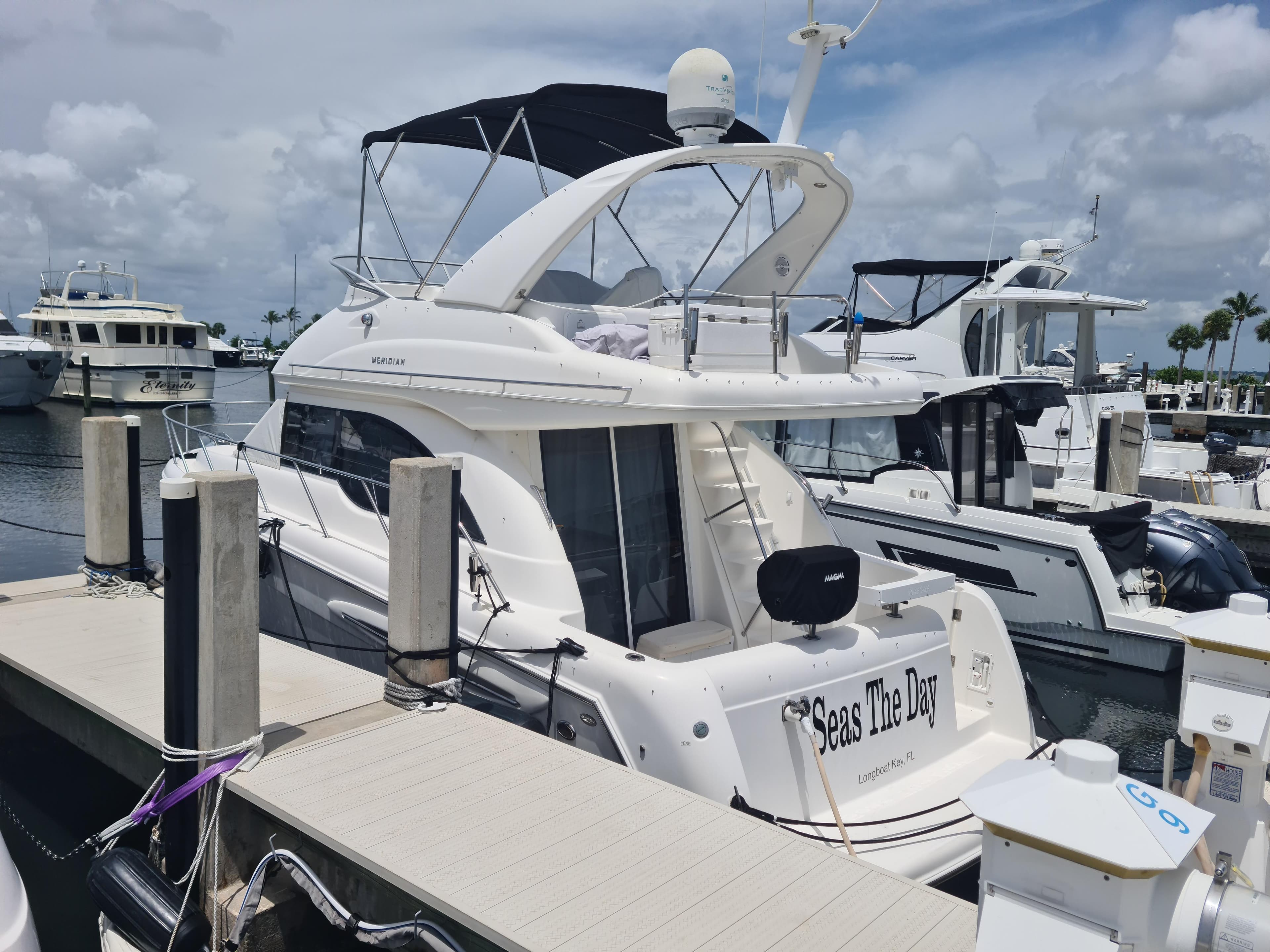 2004 Meridian 341 Sedan yacht docked at marina under cloudy sky.