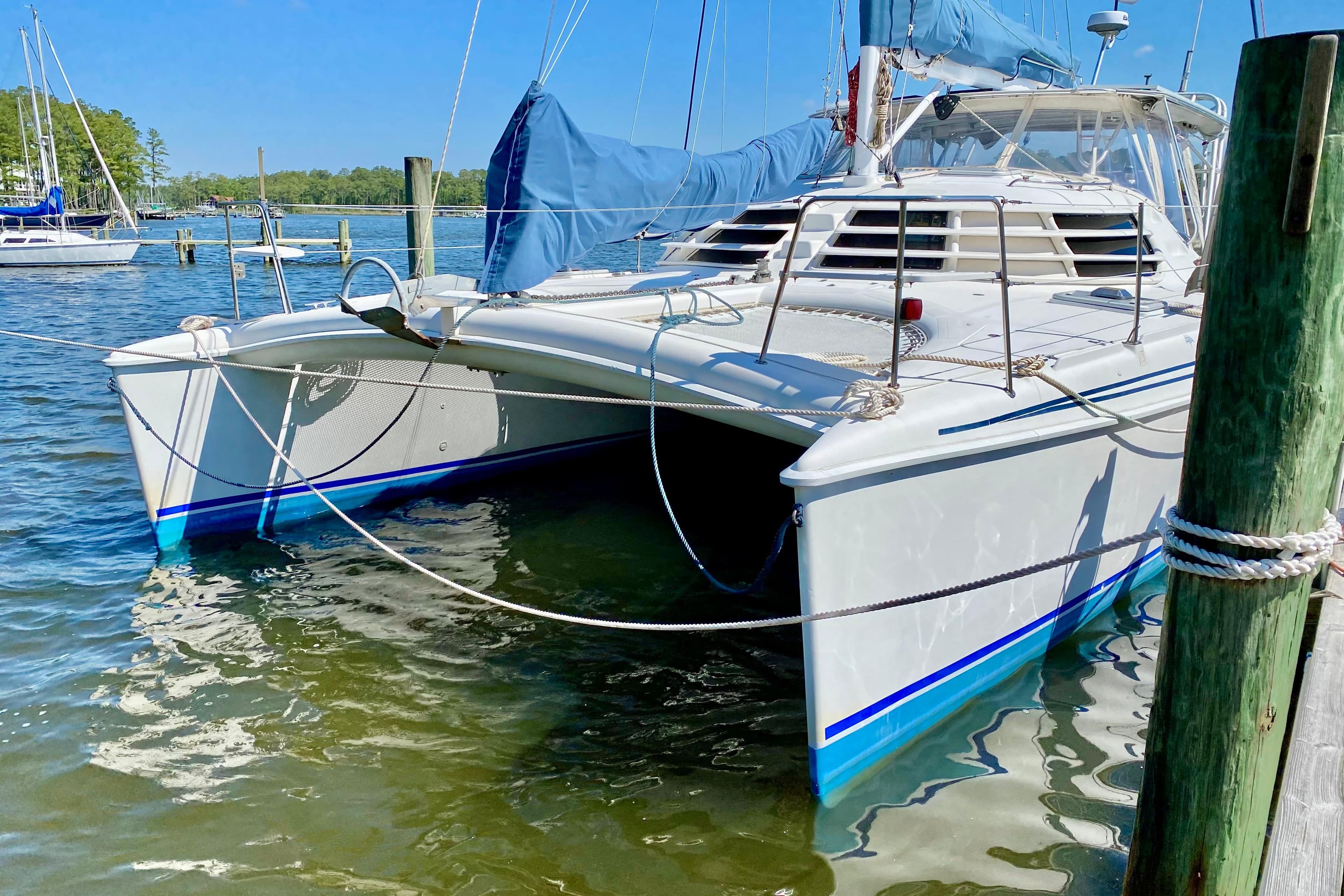 1998 Manta 40 catamaran docked in a sunny marina, featuring blue accents.