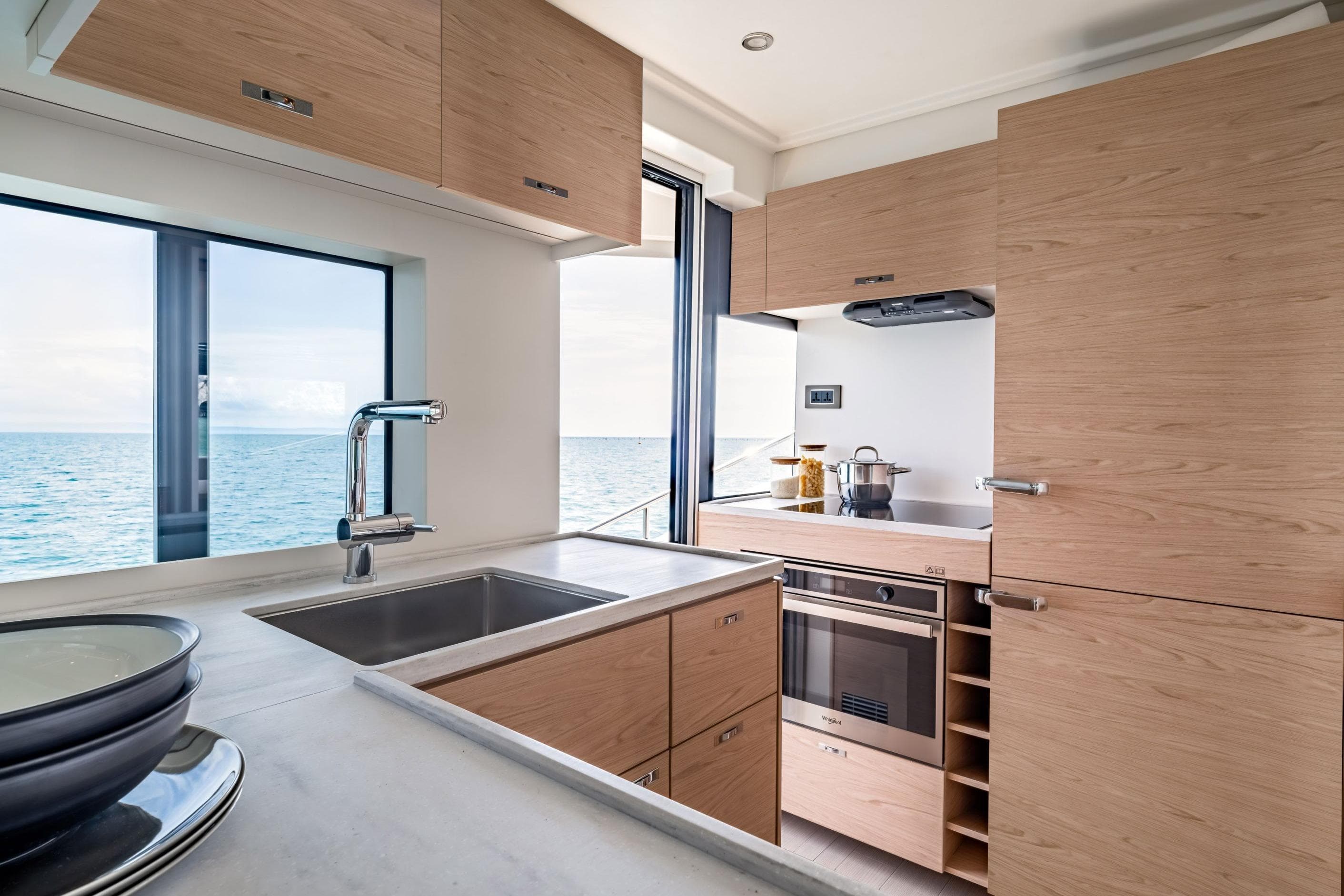 Modern kitchen interior on 2025 Beneteau Grand Trawler 63 yacht with ocean view.