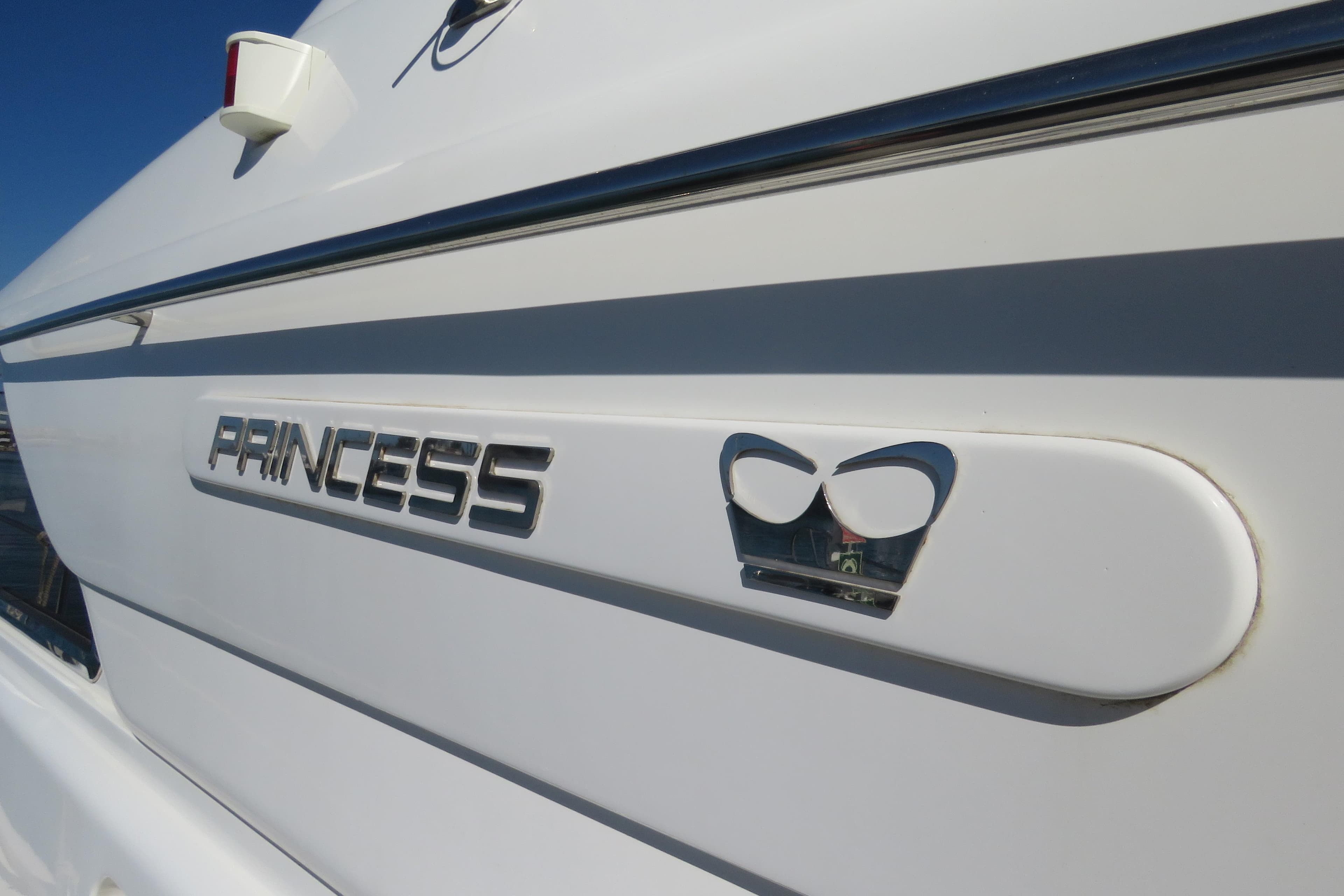 Side view of a 1995 Princess 60 yacht with logo and emblem.