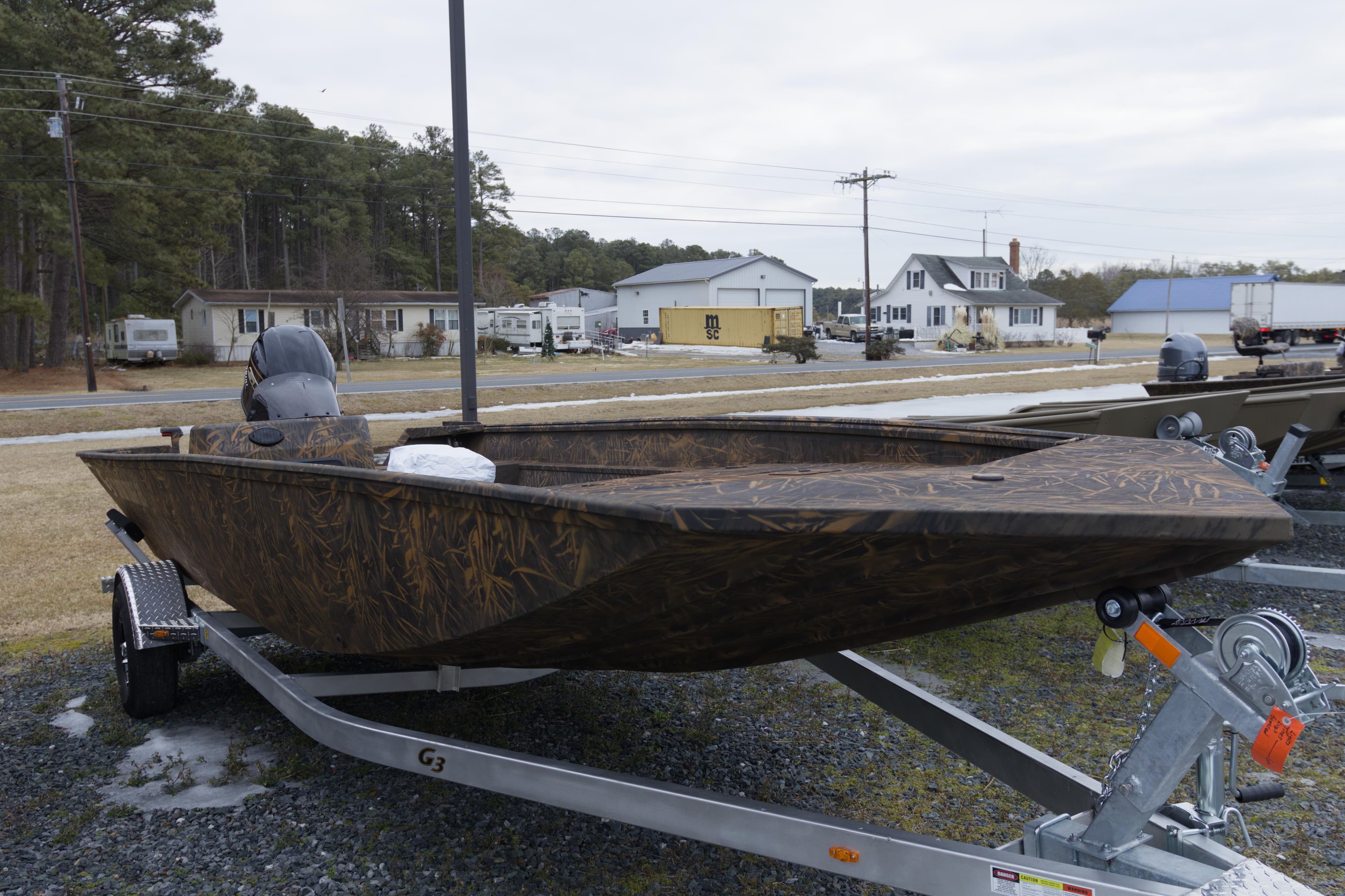 2026 G3 Gator Tough 20 SC boat on trailer, camo design, parked outdoors.