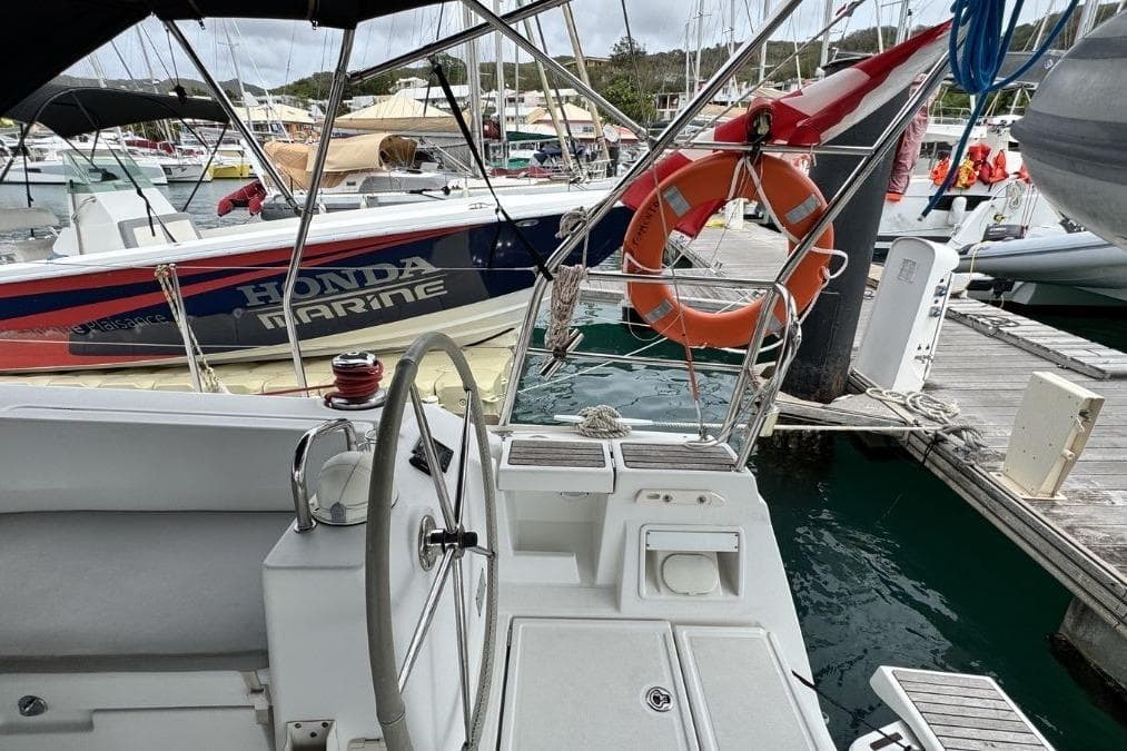 Beneteau Oceanis 41 sailboat docked at marina, featuring steering wheel and lifebuoy, 2012 model.