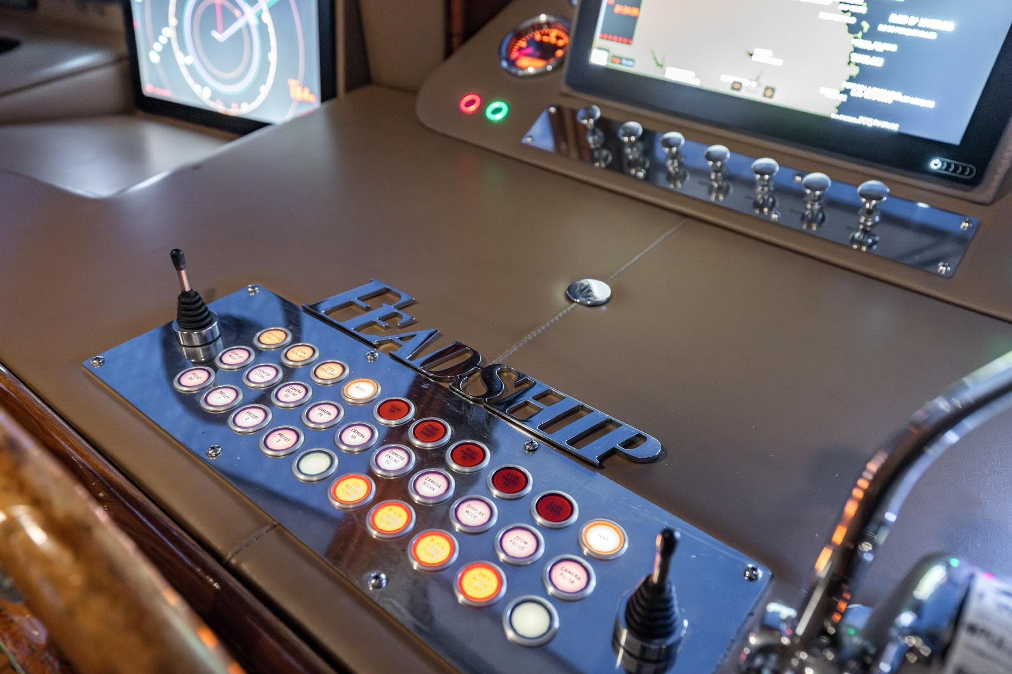 Control panel of a 1963 Feadship Classic Canoe Stern yacht with illuminated buttons and screens.