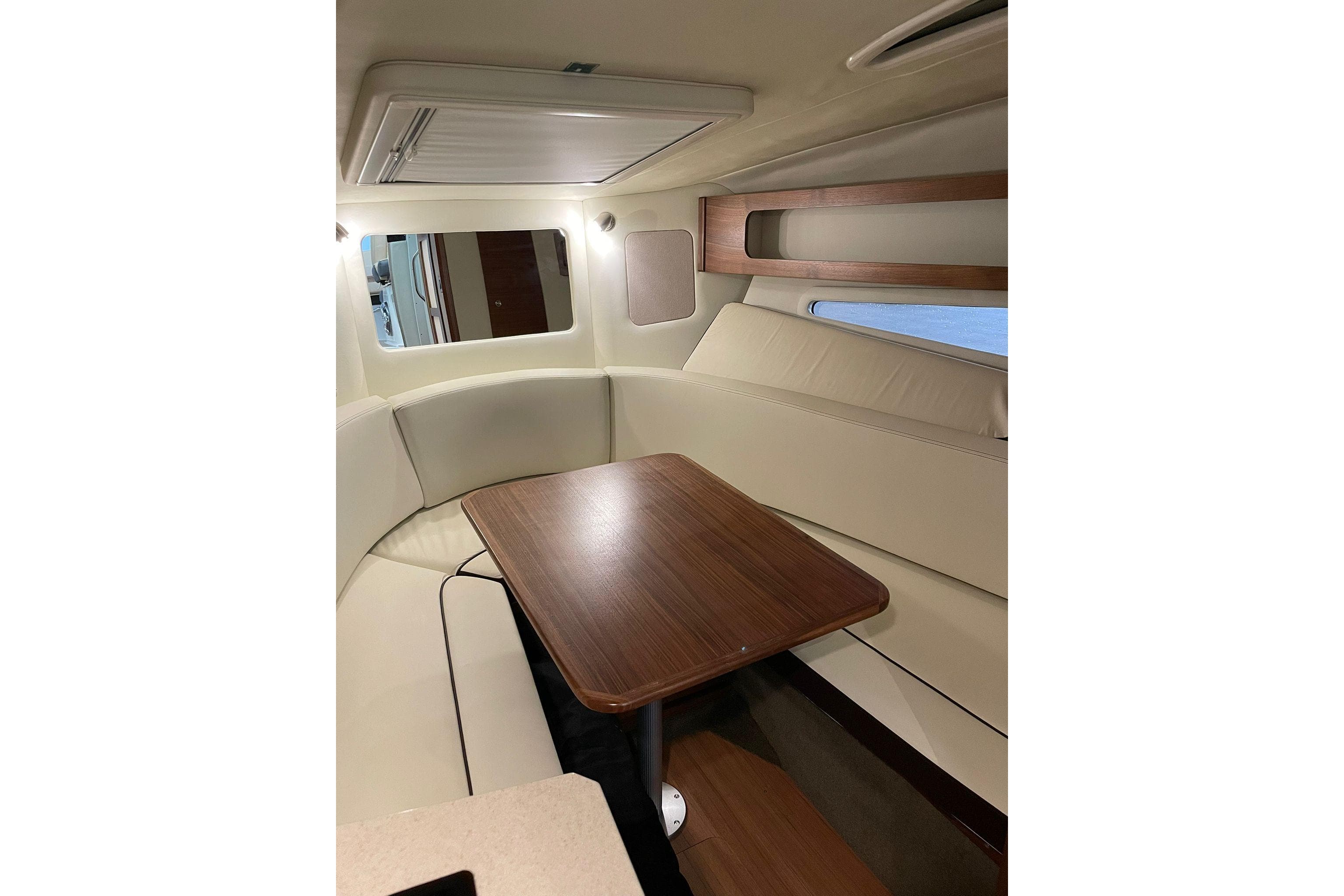 Interior of 2021 Sea Ray 265 Sundancer with elegant seating and wooden table.