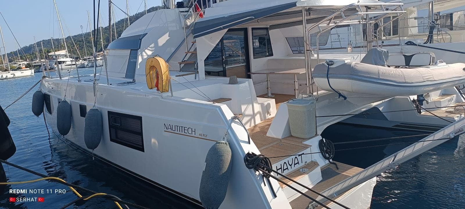 Nautitech 46 Fly 2021 catamaran docked at marina with inflatable boat.