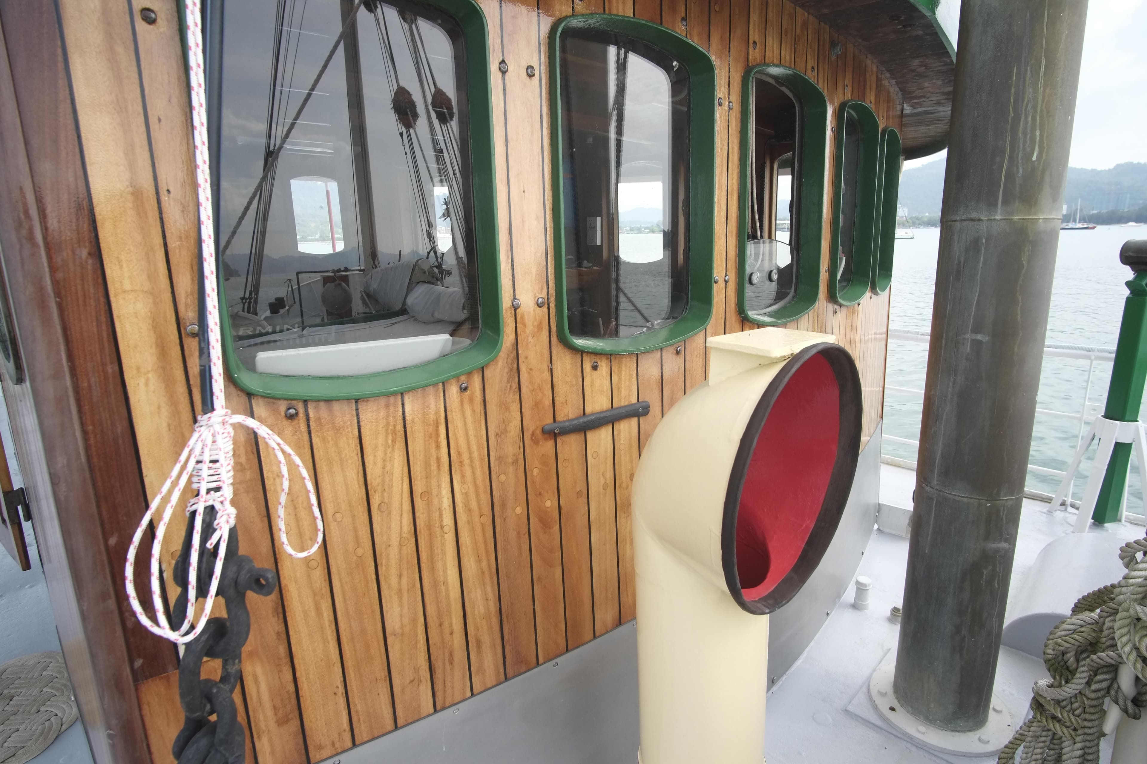 Wooden cabin of 1930 Custom Gronigen boat with green-trimmed windows and nautical details.