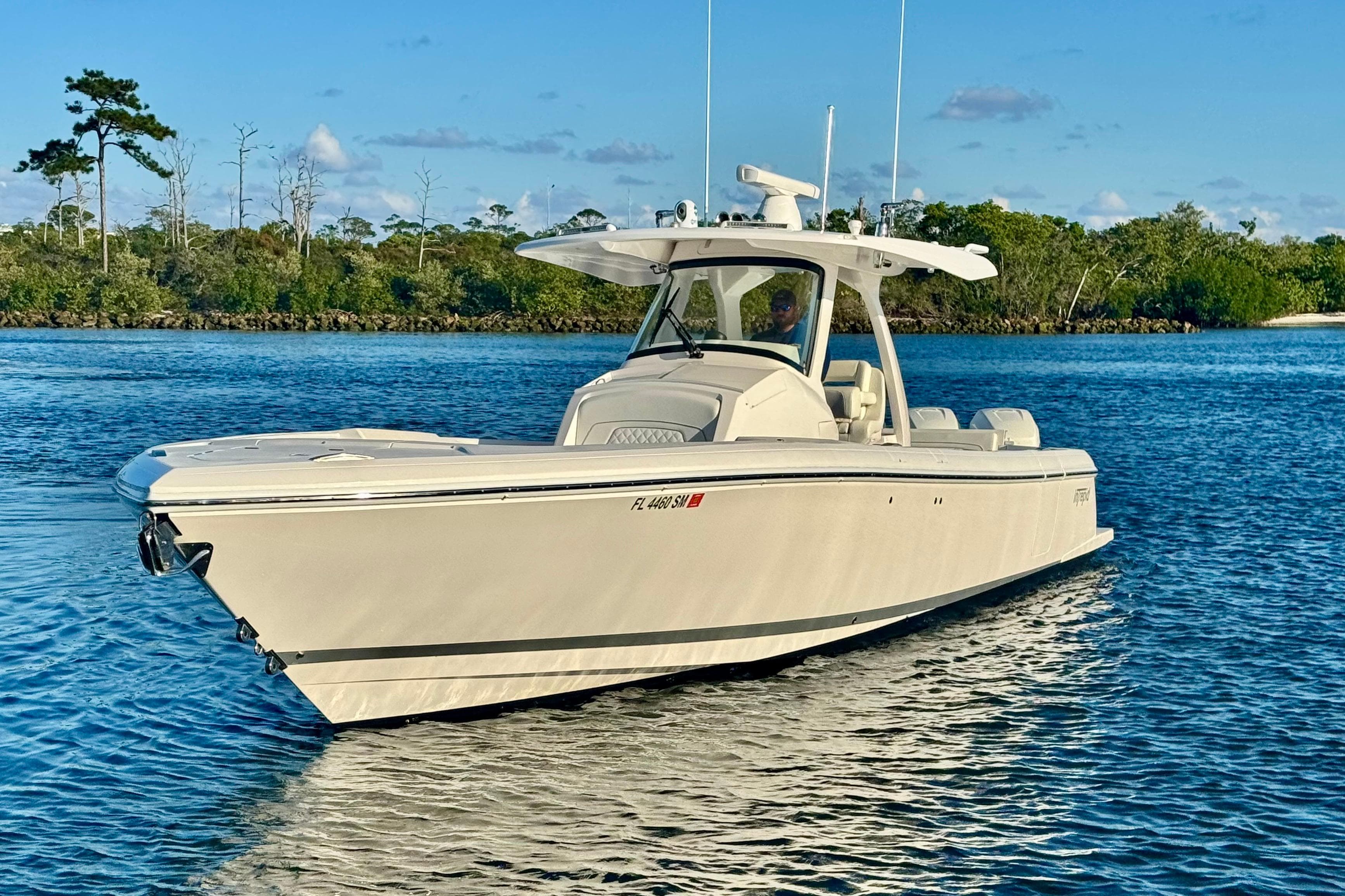 2020 Intrepid 375 Nomad SE boat on calm water, surrounded by lush greenery.