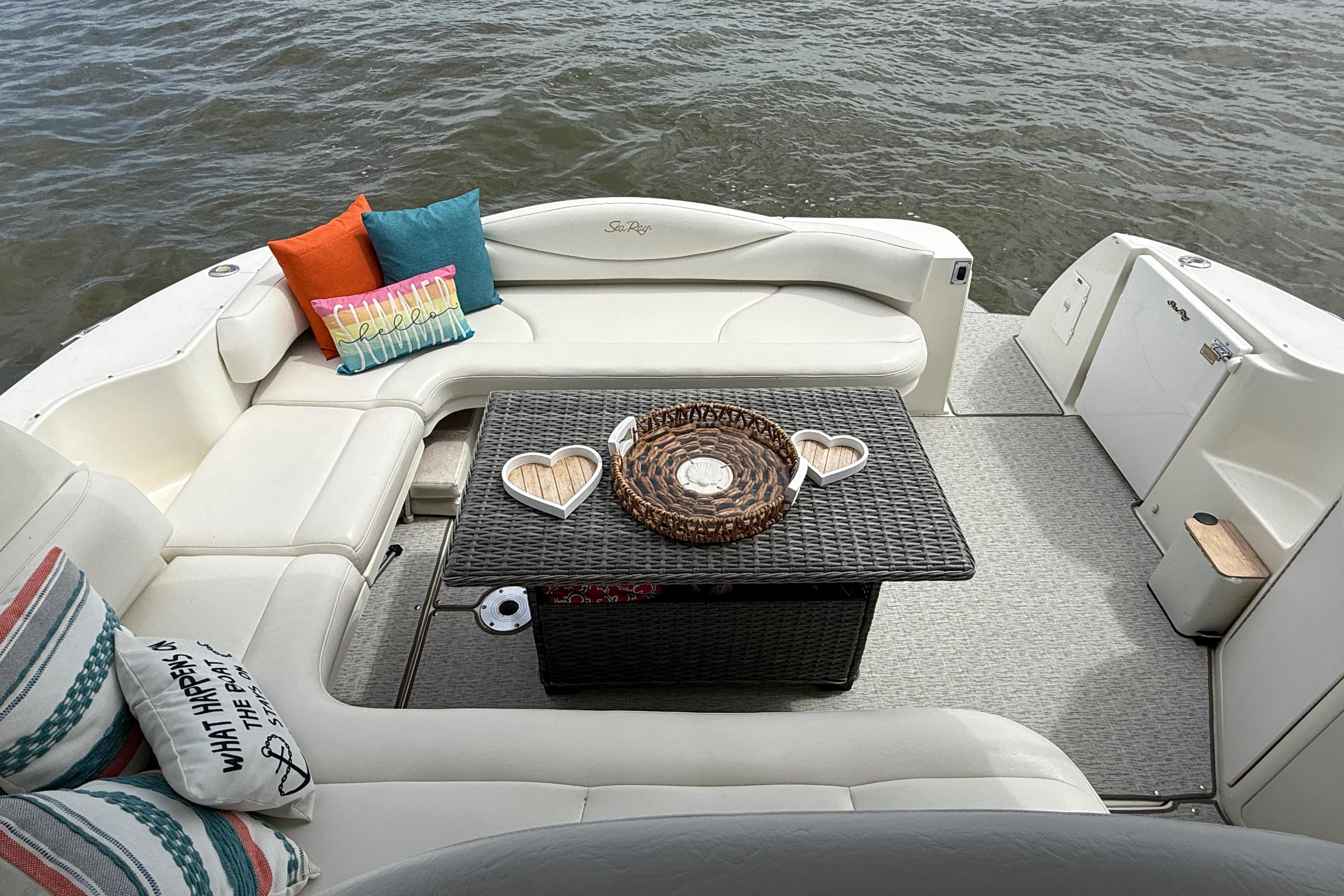 Luxurious 2000 Sea Ray 410 Sundancer boat interior with cozy seating and decorative pillows.