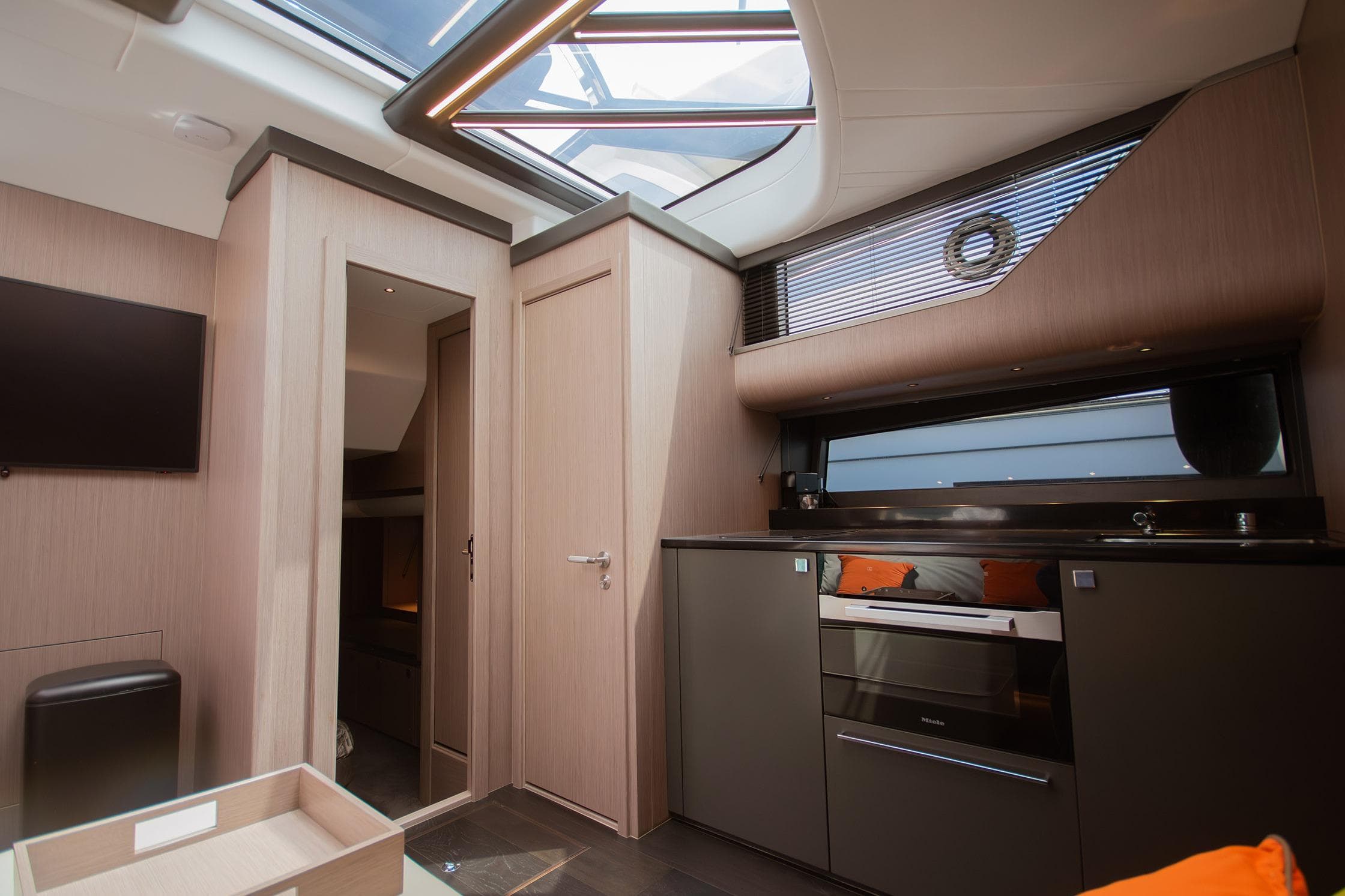 Luxurious interior of 2024 Sunseeker Superhawk 55 yacht with modern kitchen and skylight.