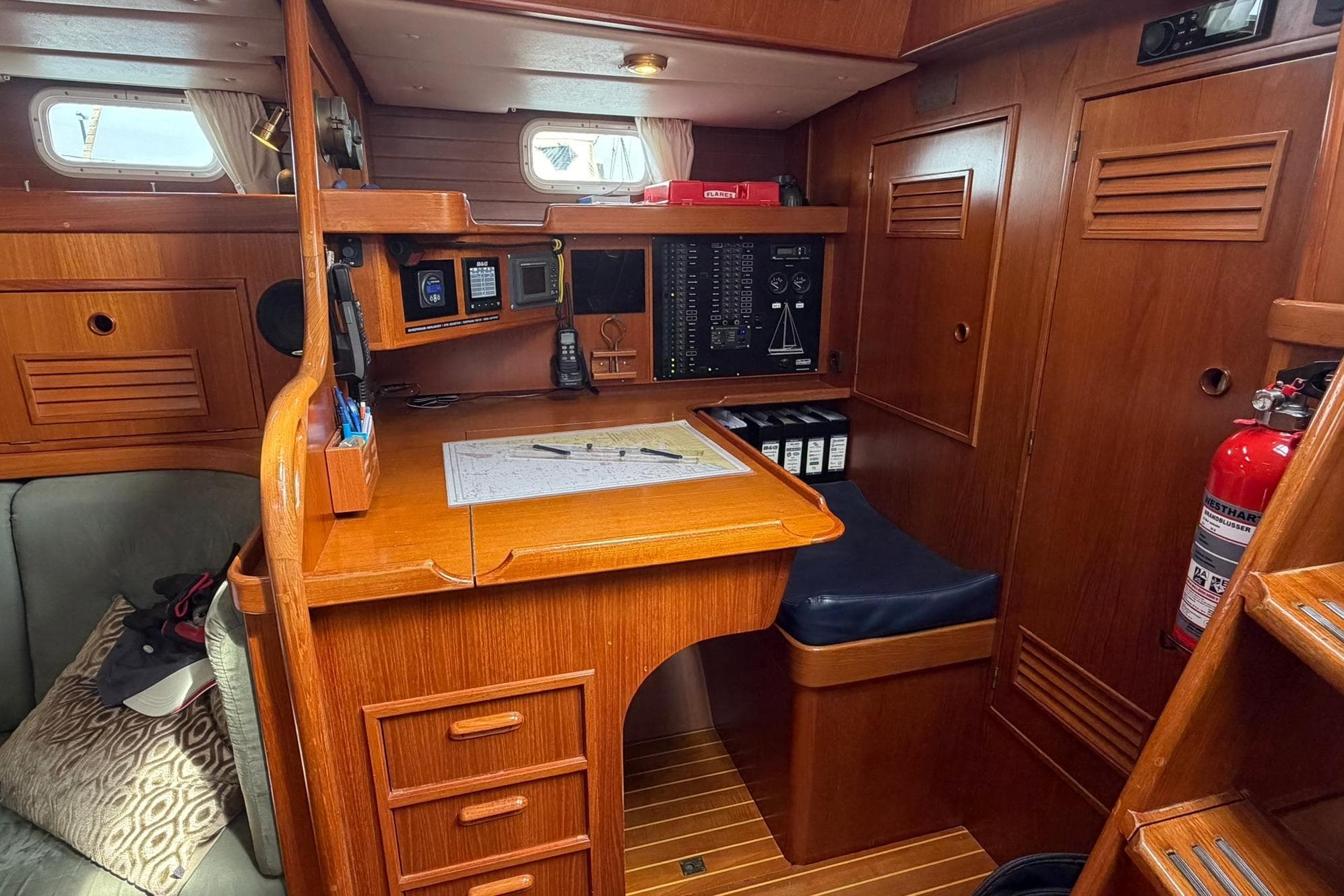 Navigation station inside a 1997 Contest 46-48 yacht, featuring wooden cabinetry and nautical equipment.