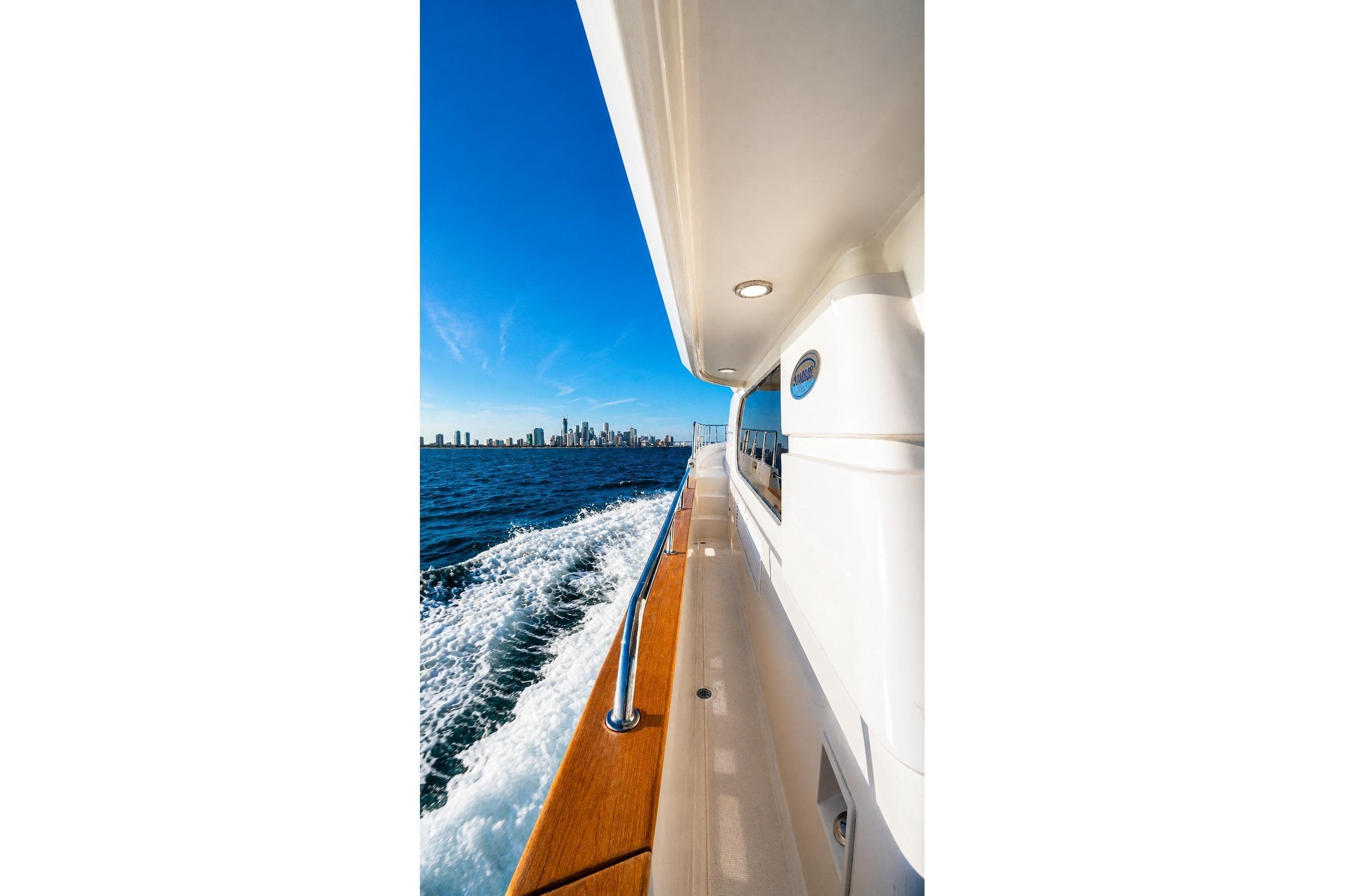 Side view of a 2005 Symbol 58 Pilothouse yacht cruising with city skyline in background.