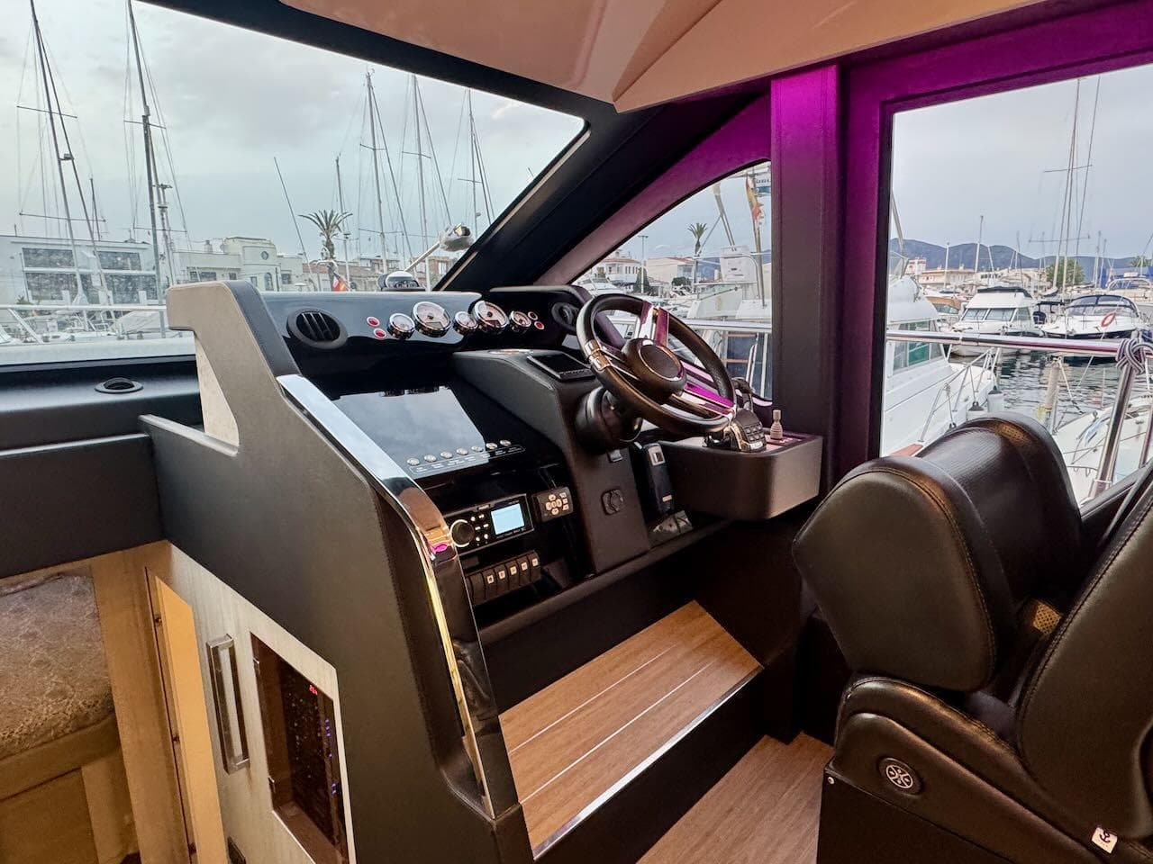 2017 Cranchi E 52 F yacht helm with modern controls and marina view.