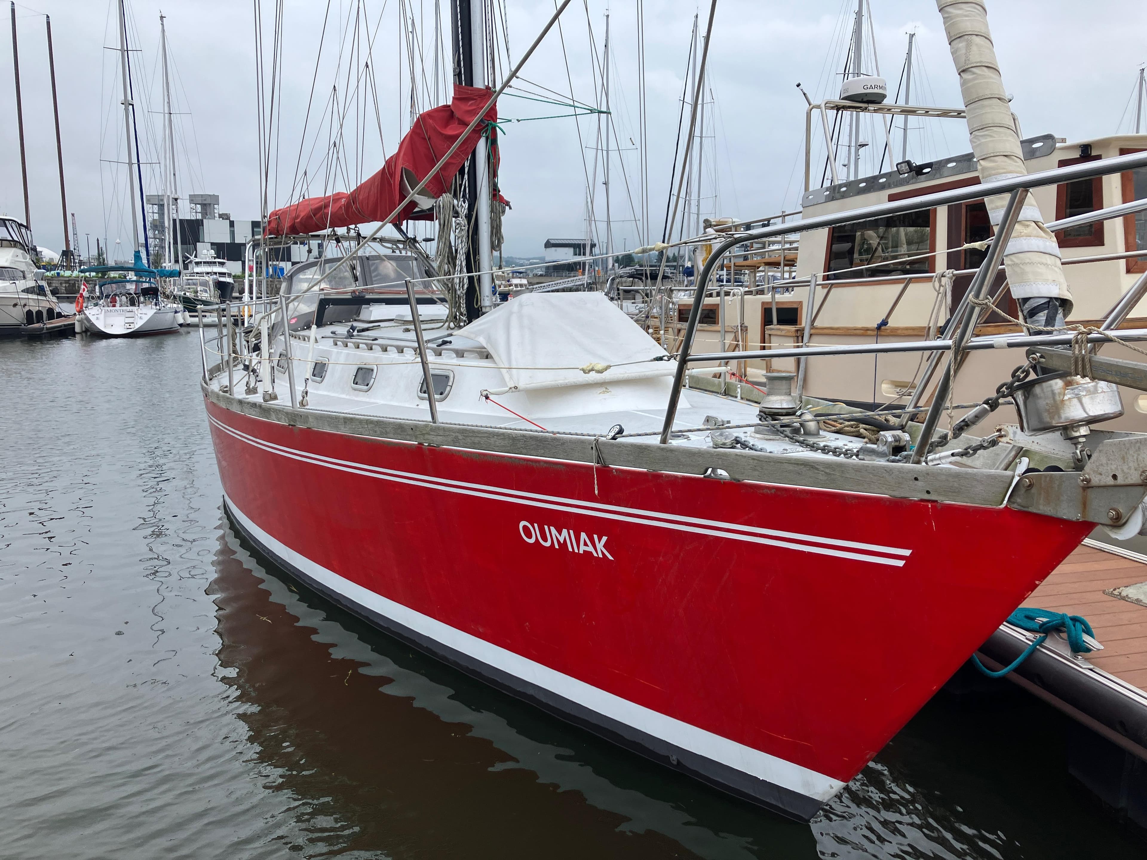 Red MetalCraft Amazon 41 sailboat, 1987 model, docked in a marina.
