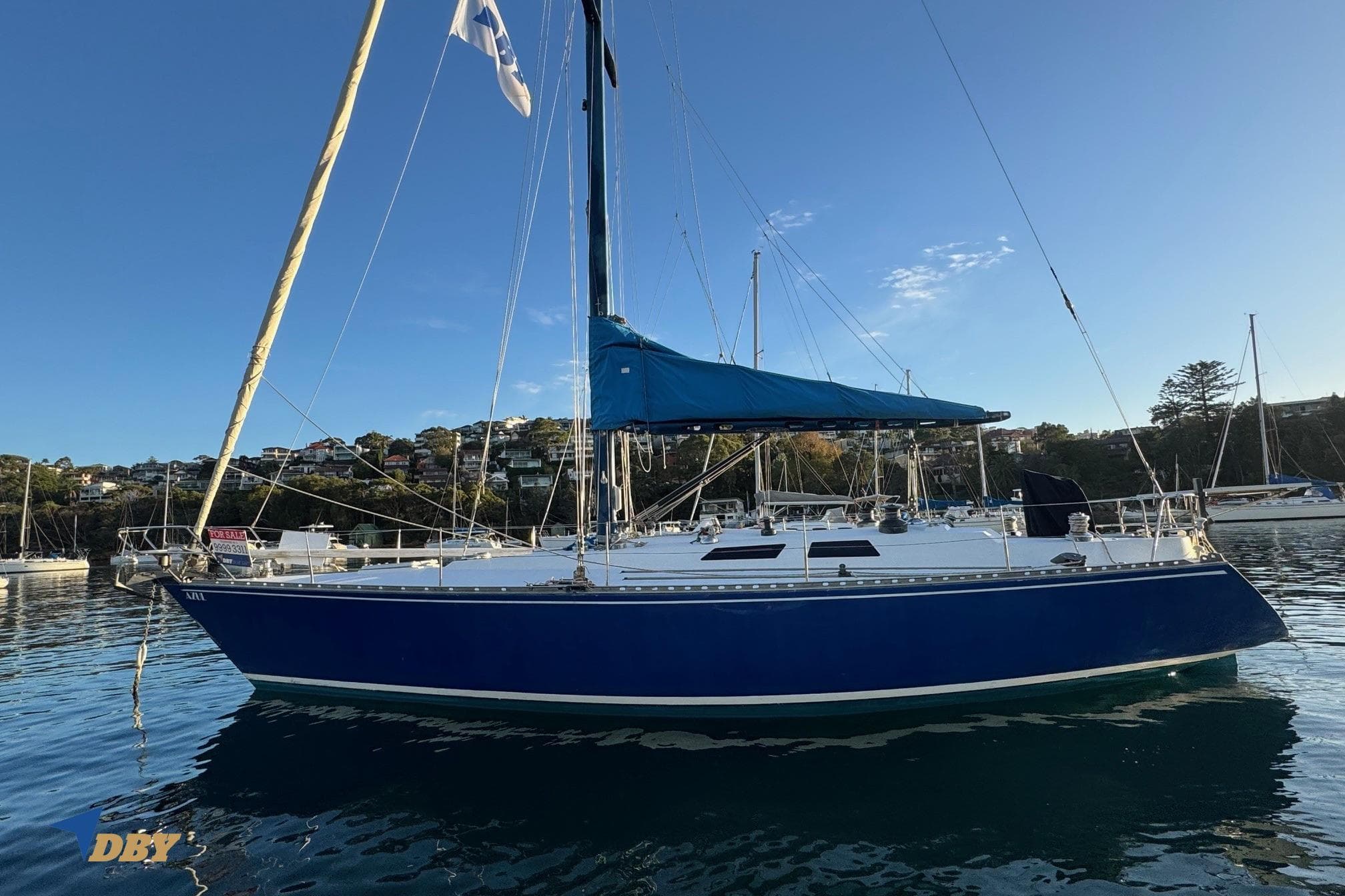 1981 Baltic 42 sailboat with blue hull and sails, anchored in a scenic harbor.