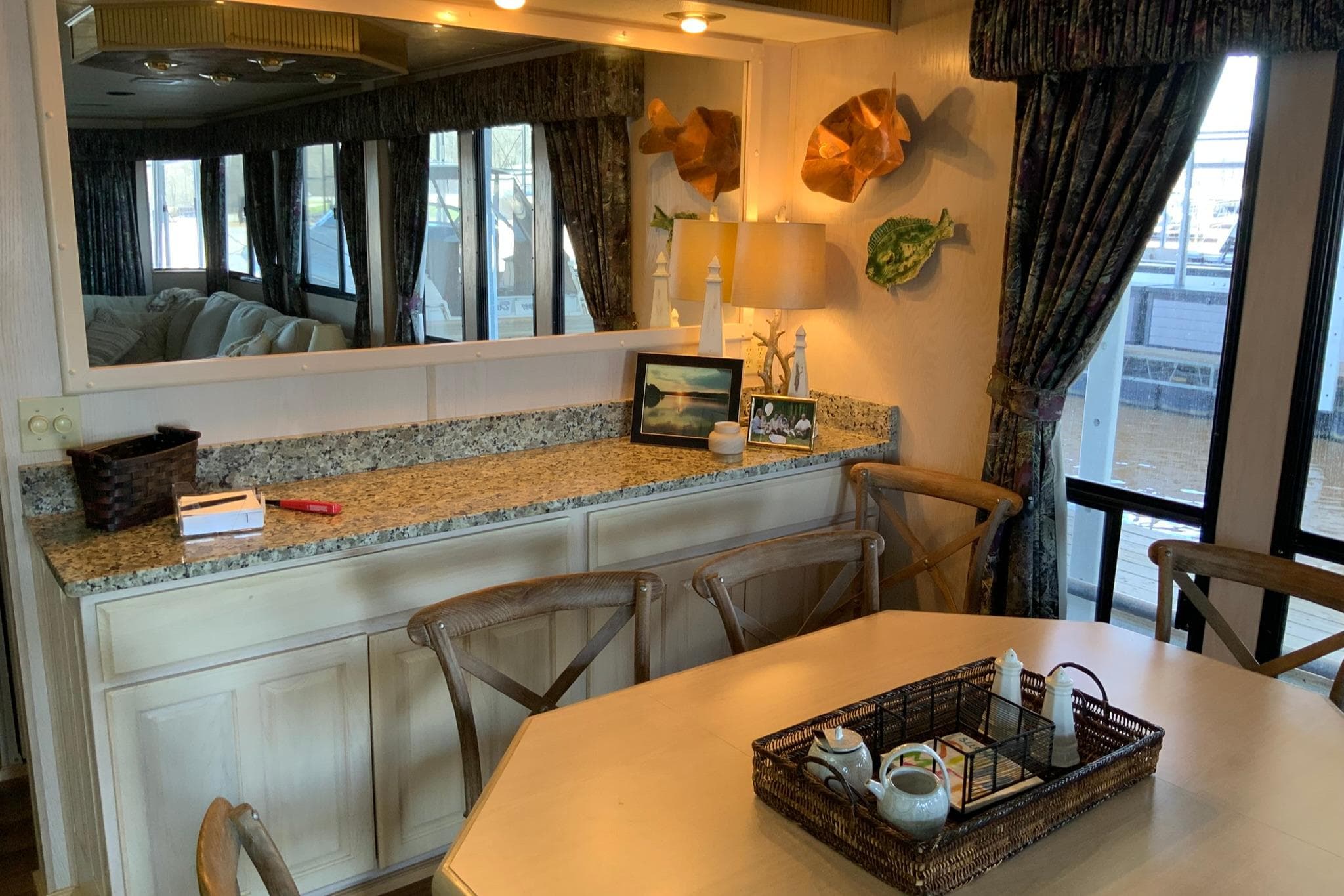 Dining area in a 1997 Lakeview houseboat with wooden chairs and decorative elements.