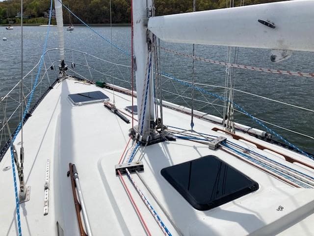 Sailboat deck of 1988 C&C 41 with rigging and hatches on calm water.
