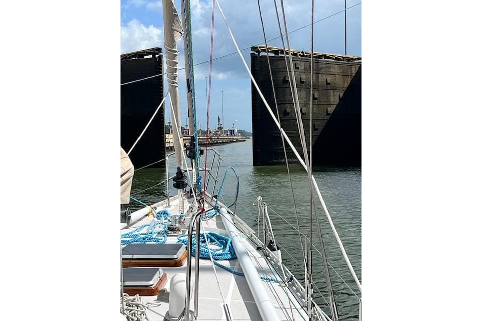 Sailing through canal lock on 1985 Robert Clark Ketch, blue skies above.