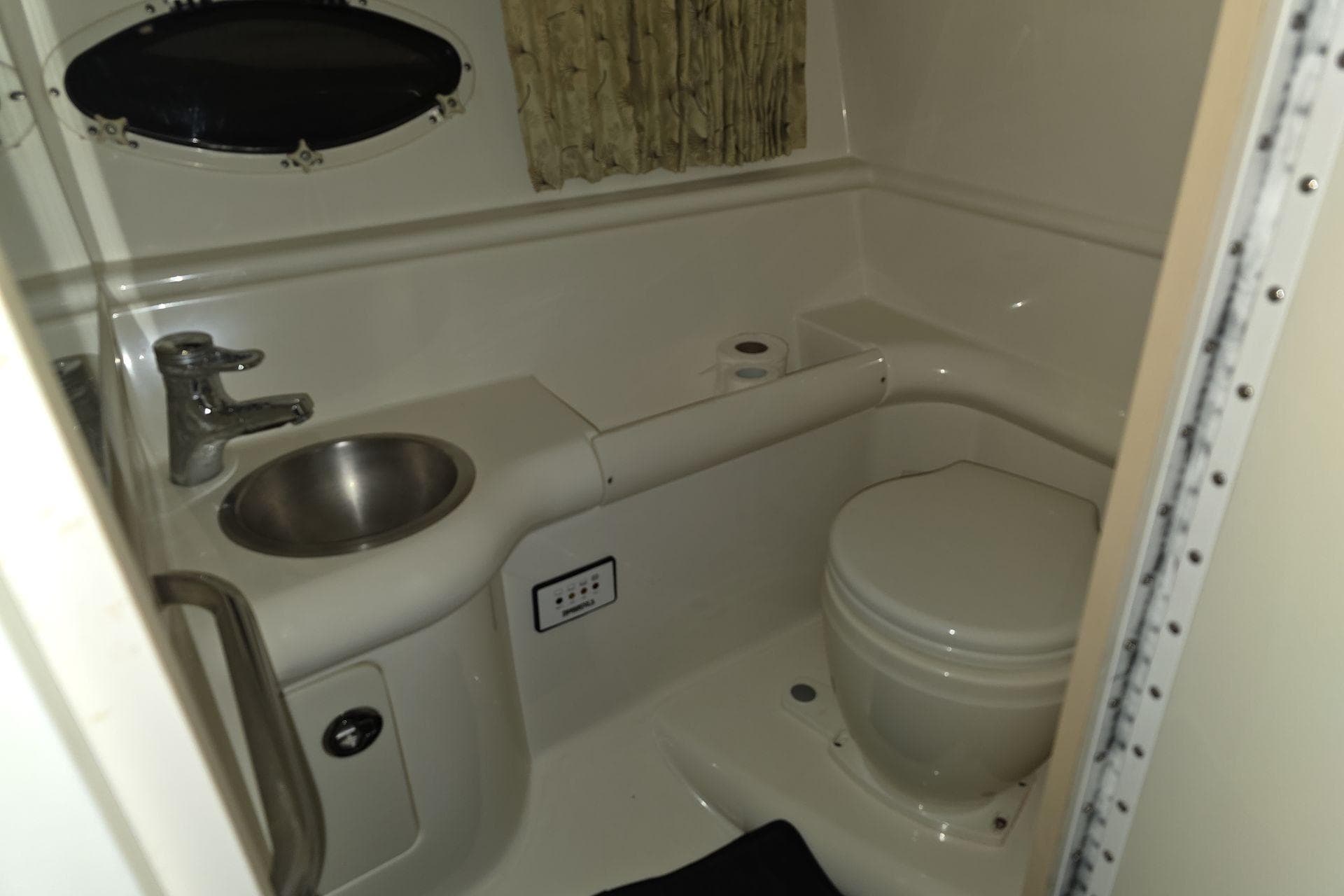 Compact bathroom in 2000 Formula 330 Sun Sport boat with sink and toilet.