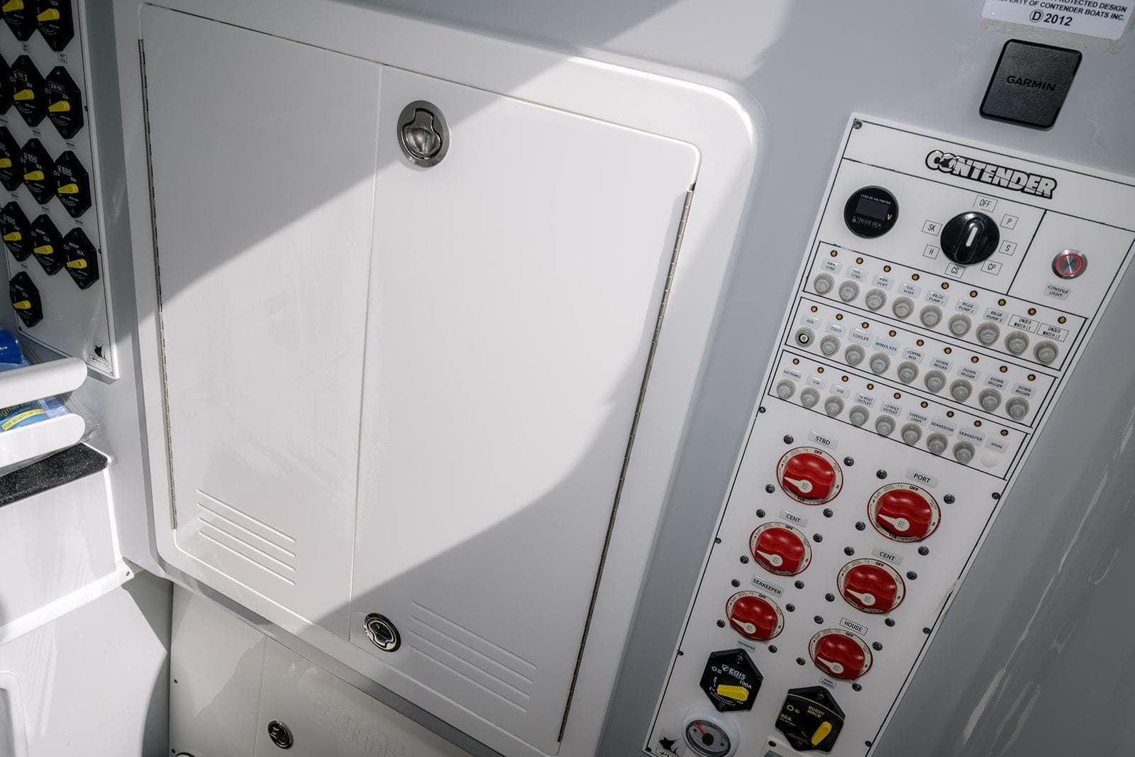 2024 Contender 44 ST boat control panel with switches and storage compartment.