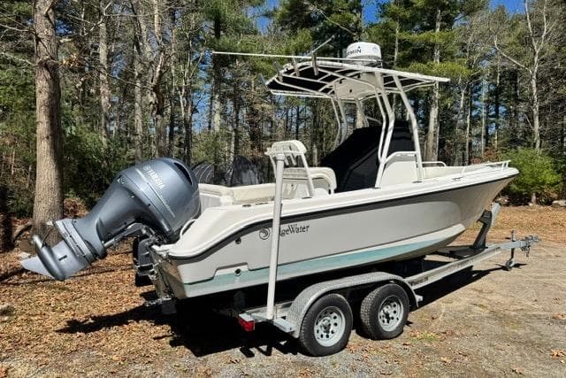 2021 Edgewater 208CC boat on trailer in wooded area.