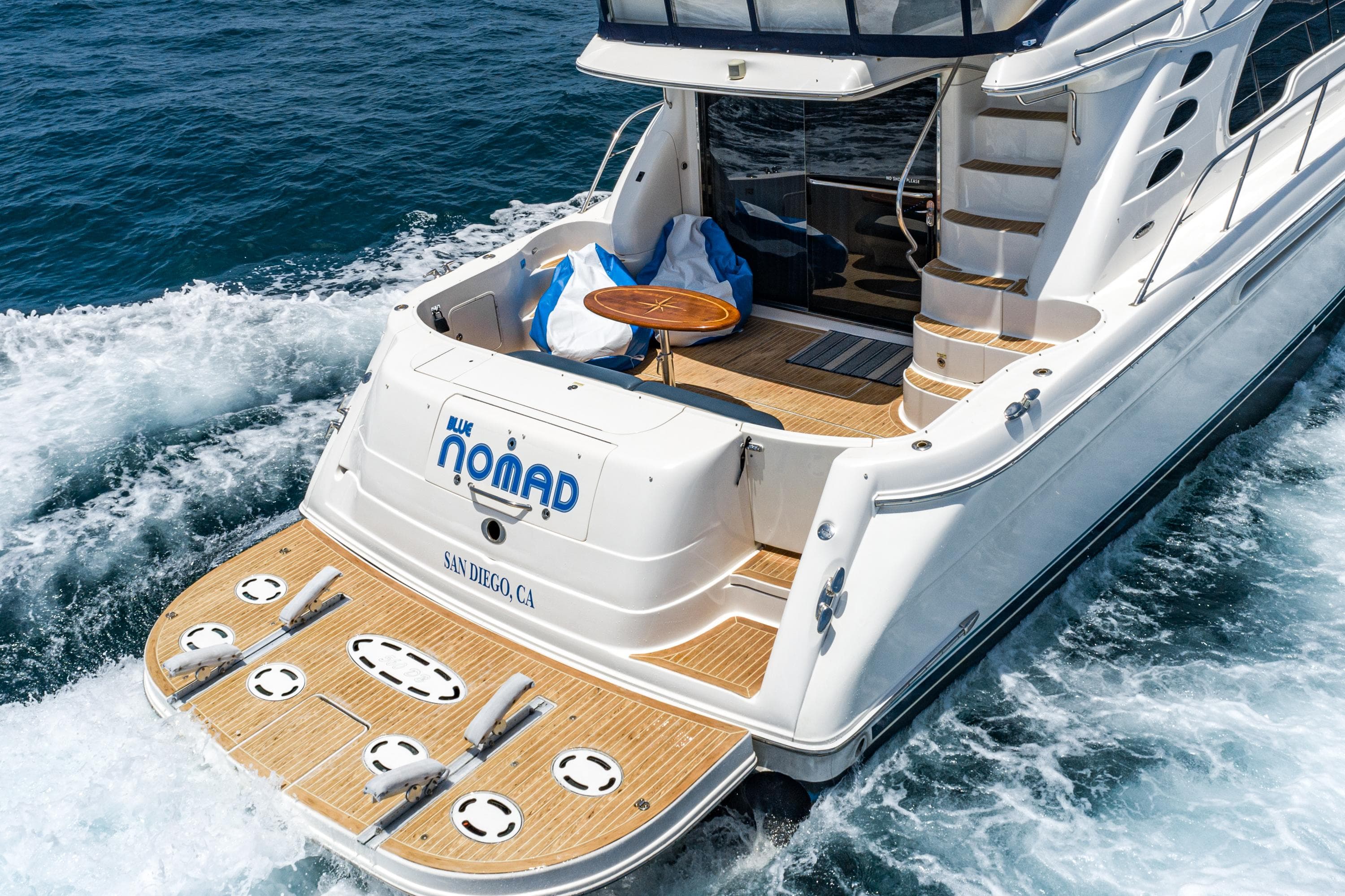 2001 Sea Ray 560 Sedan Bridge yacht cruising on ocean waters, rear view.