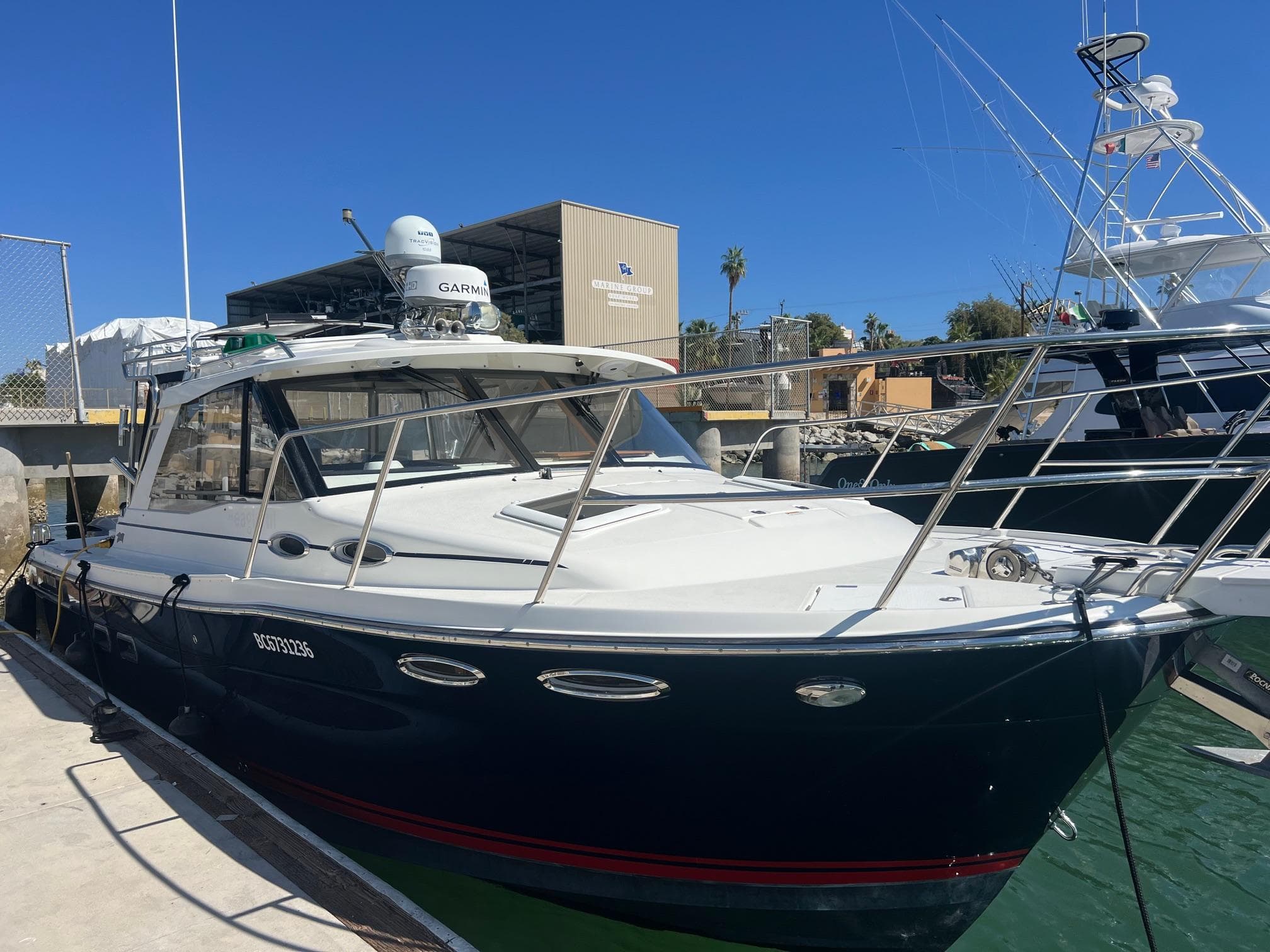 2017 Cutwater C-302 Sport Coupe docked at marina under clear blue sky.