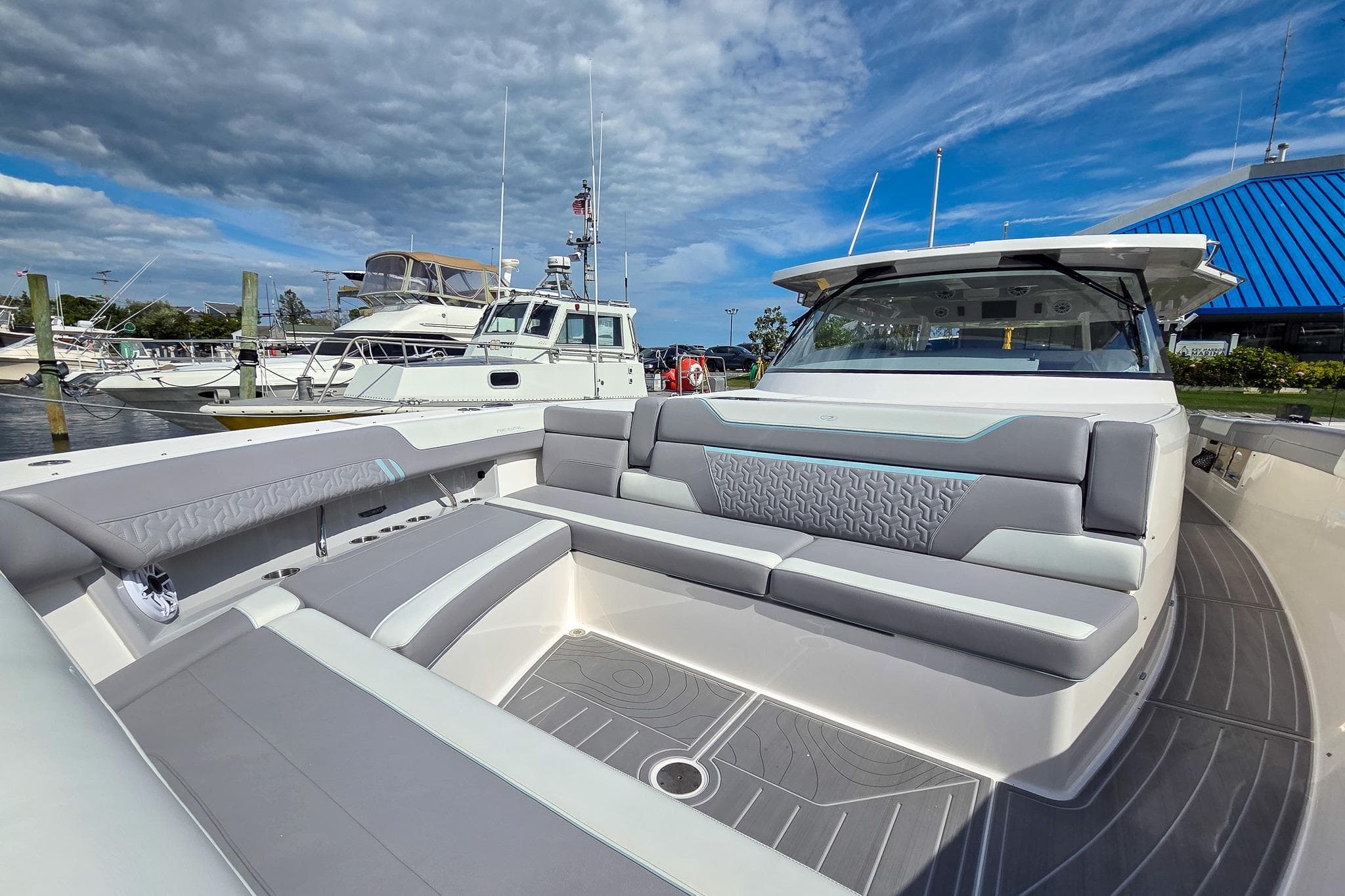 2025 Regal 50 SAV luxury yacht interior with modern seating, docked at marina under blue sky.