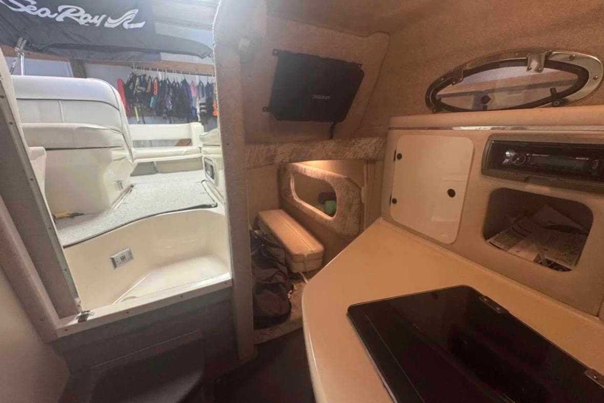Interior view of a 1995 Sea Ray 250 Sundancer cabin with seating and storage.
