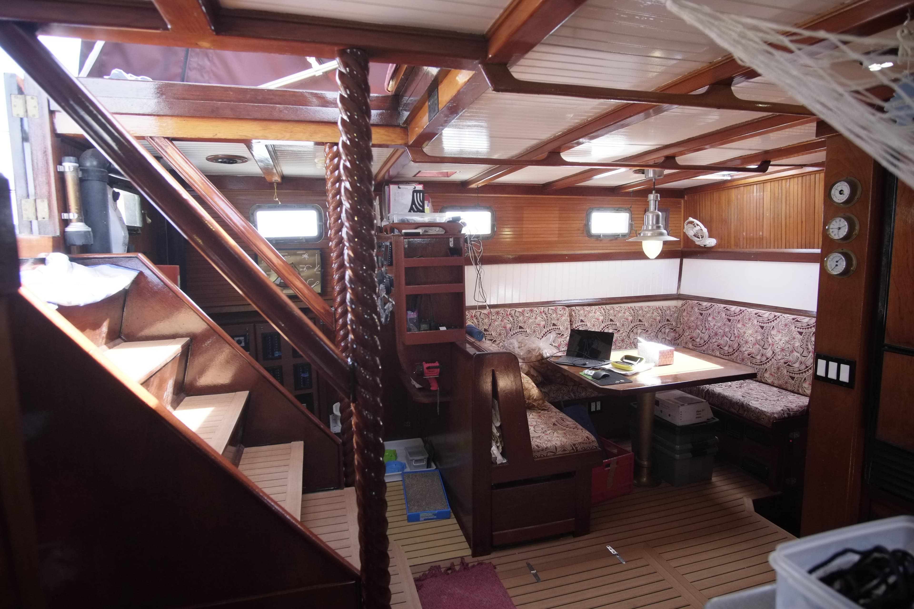 Interior of 2006 Custom Bud Macintosh schooner with wooden furnishings and cozy seating area.