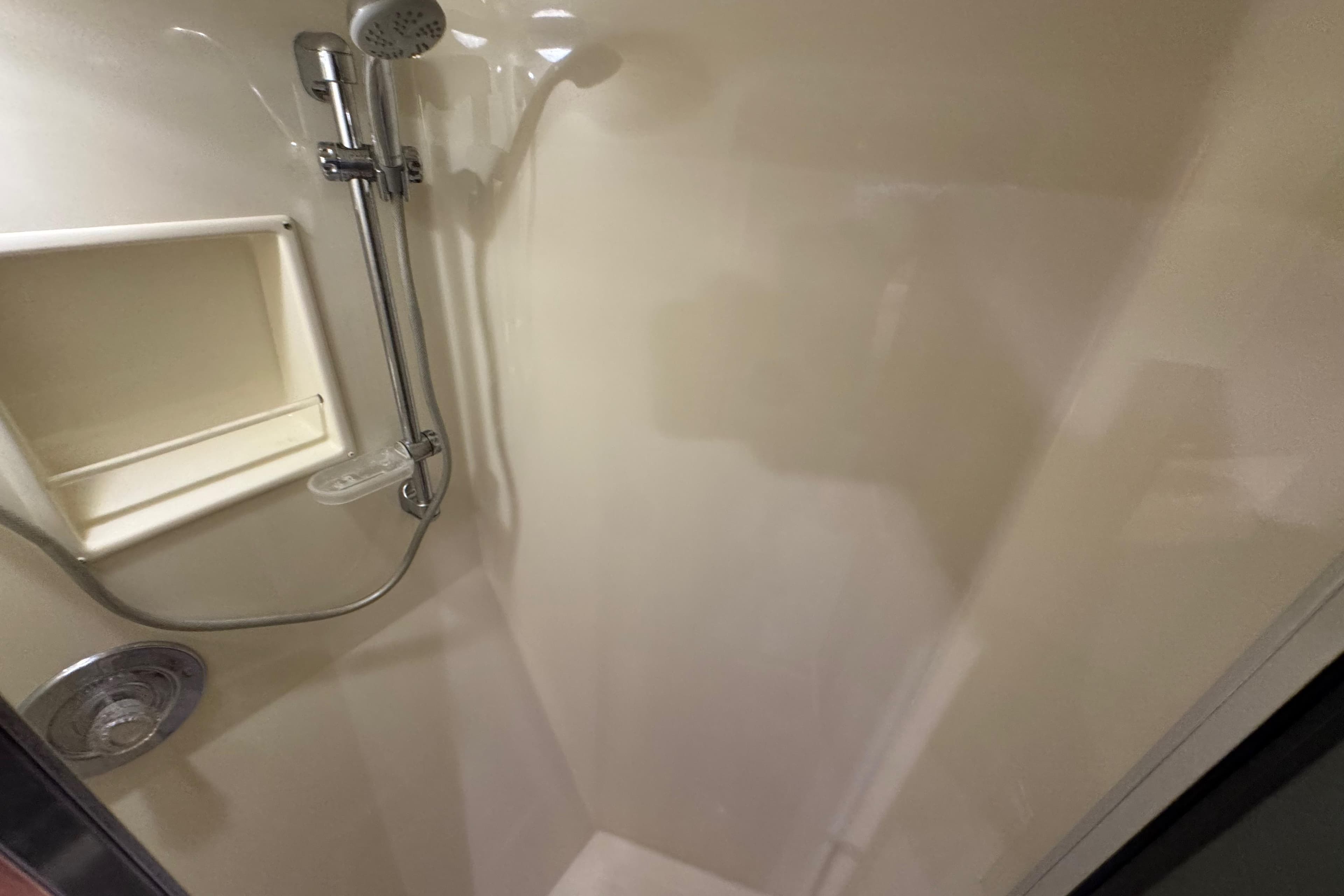 Shower area in 1995 Viking 58 Convertible yacht, featuring chrome fixtures and built-in shelf.