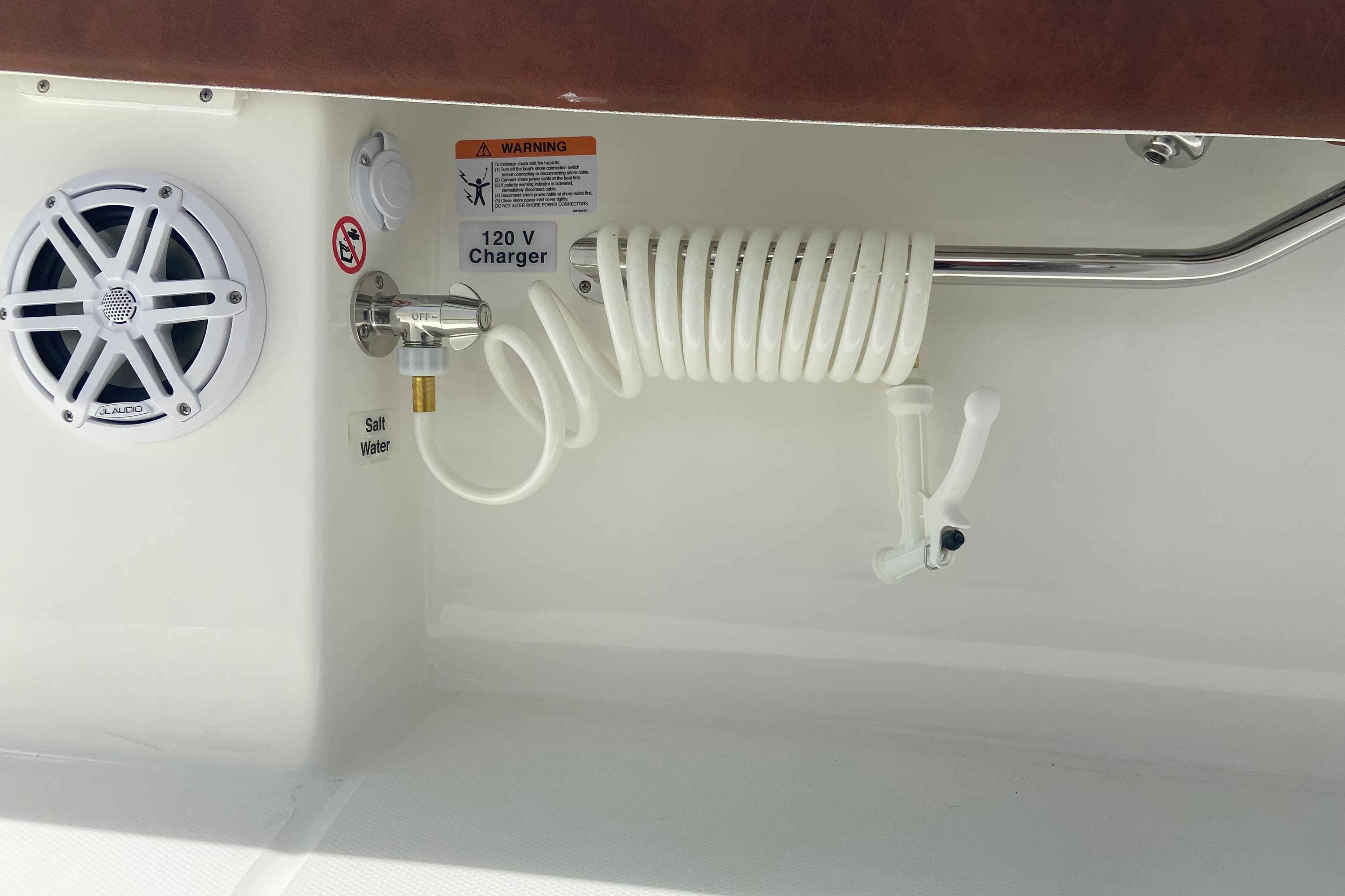 Boat interior with speaker, coiled hose, and 120V charger on Regulator 28, 2026 model.