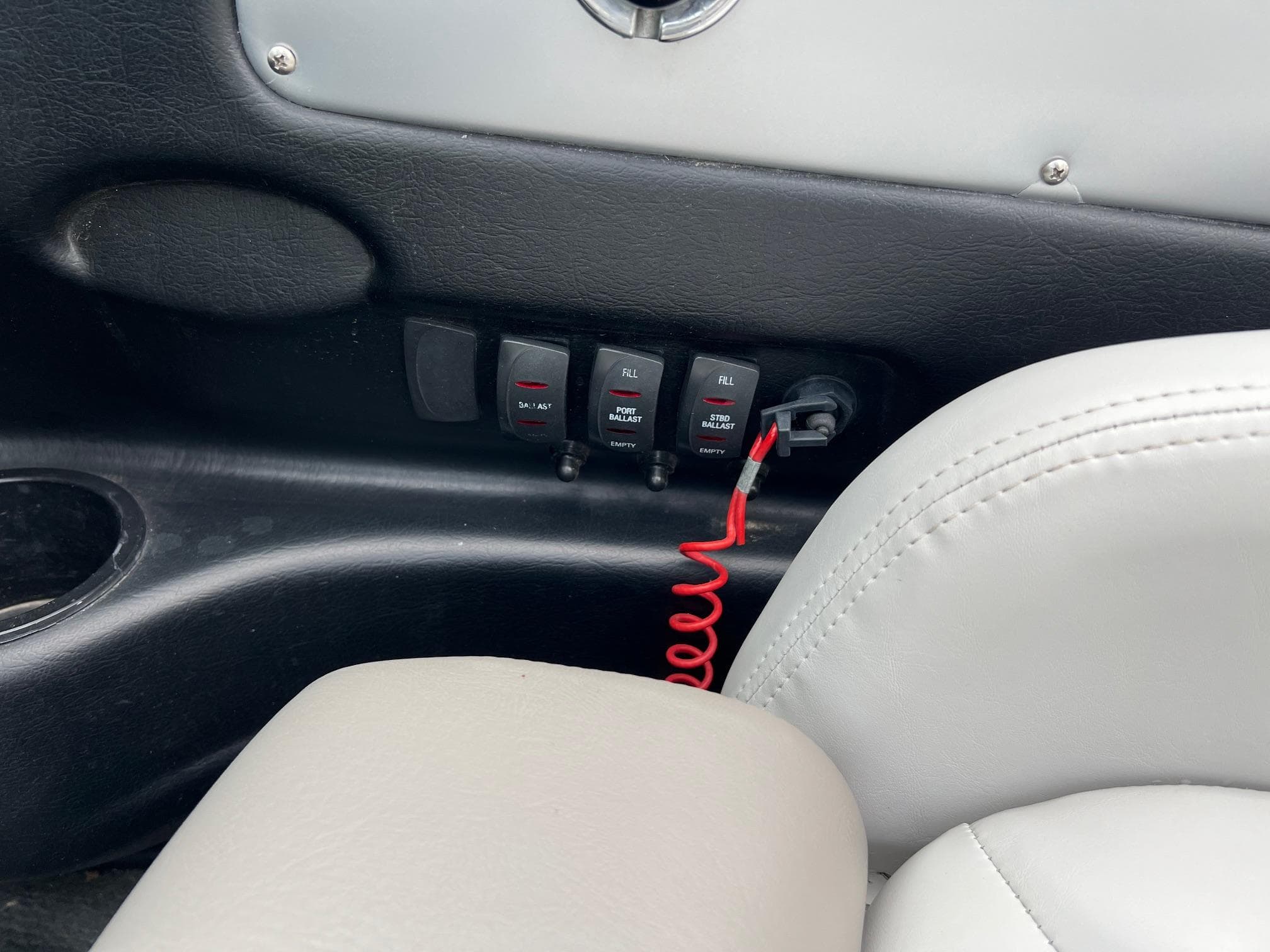 2006 MasterCraft X1 boat interior with control switches and red safety cord.