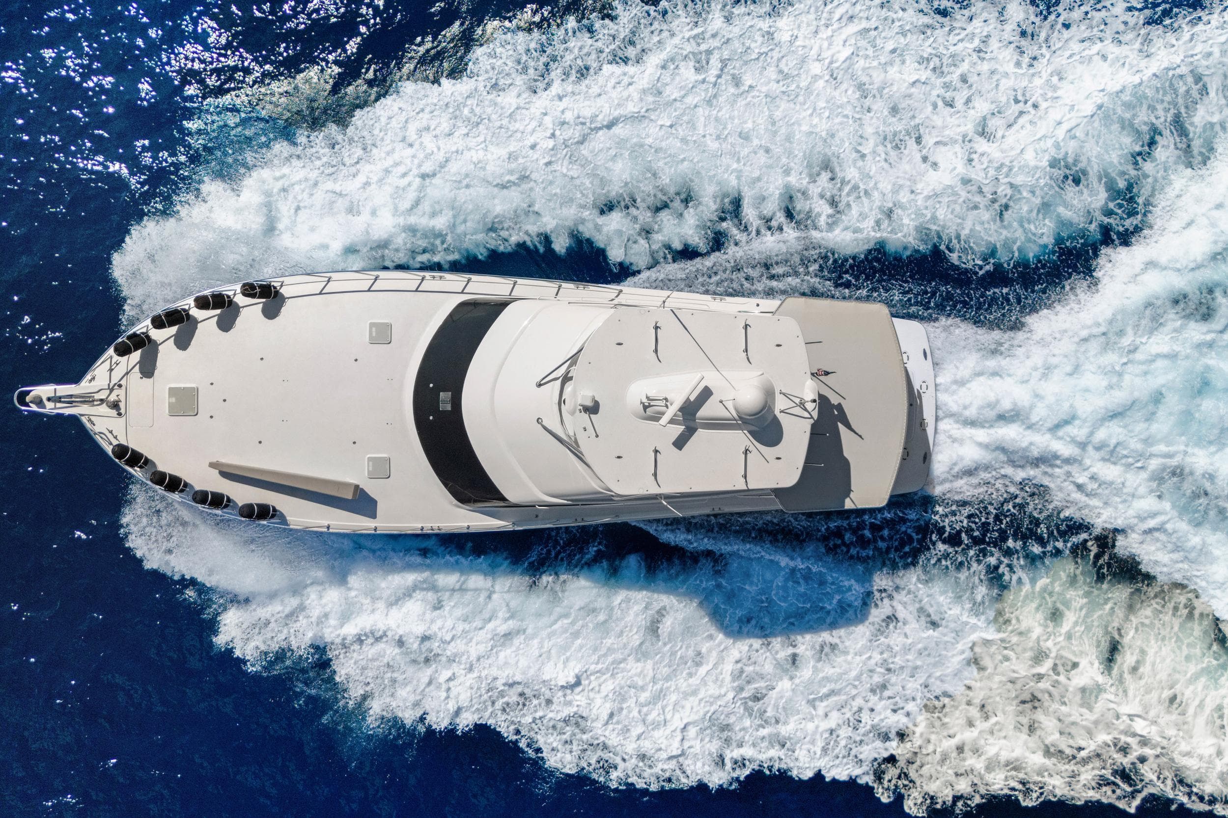Aerial view of 2016 Hatteras 63GT yacht cruising through blue ocean waters.