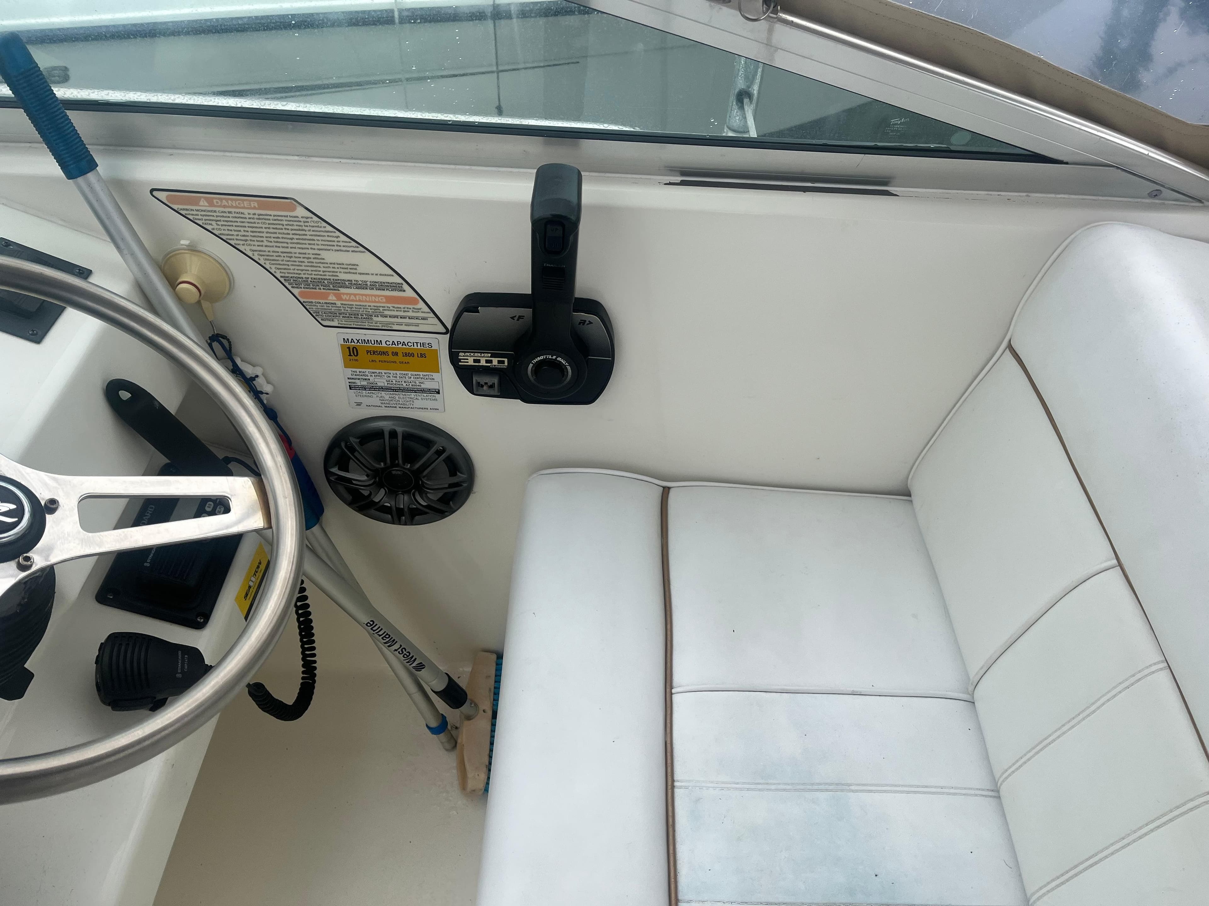 Interior of 1995 Sea Ray 250 Sundancer boat with steering wheel and seating.